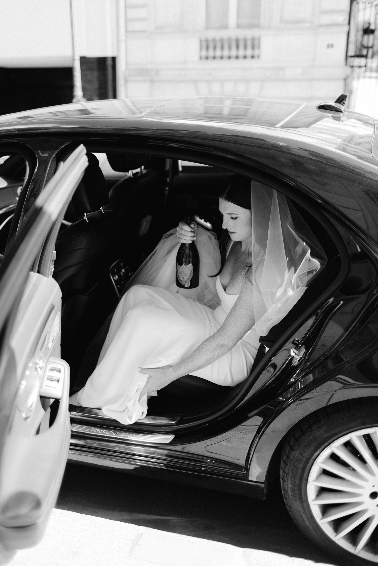 Luxury wedding car arrival captured in classic black and white photography.