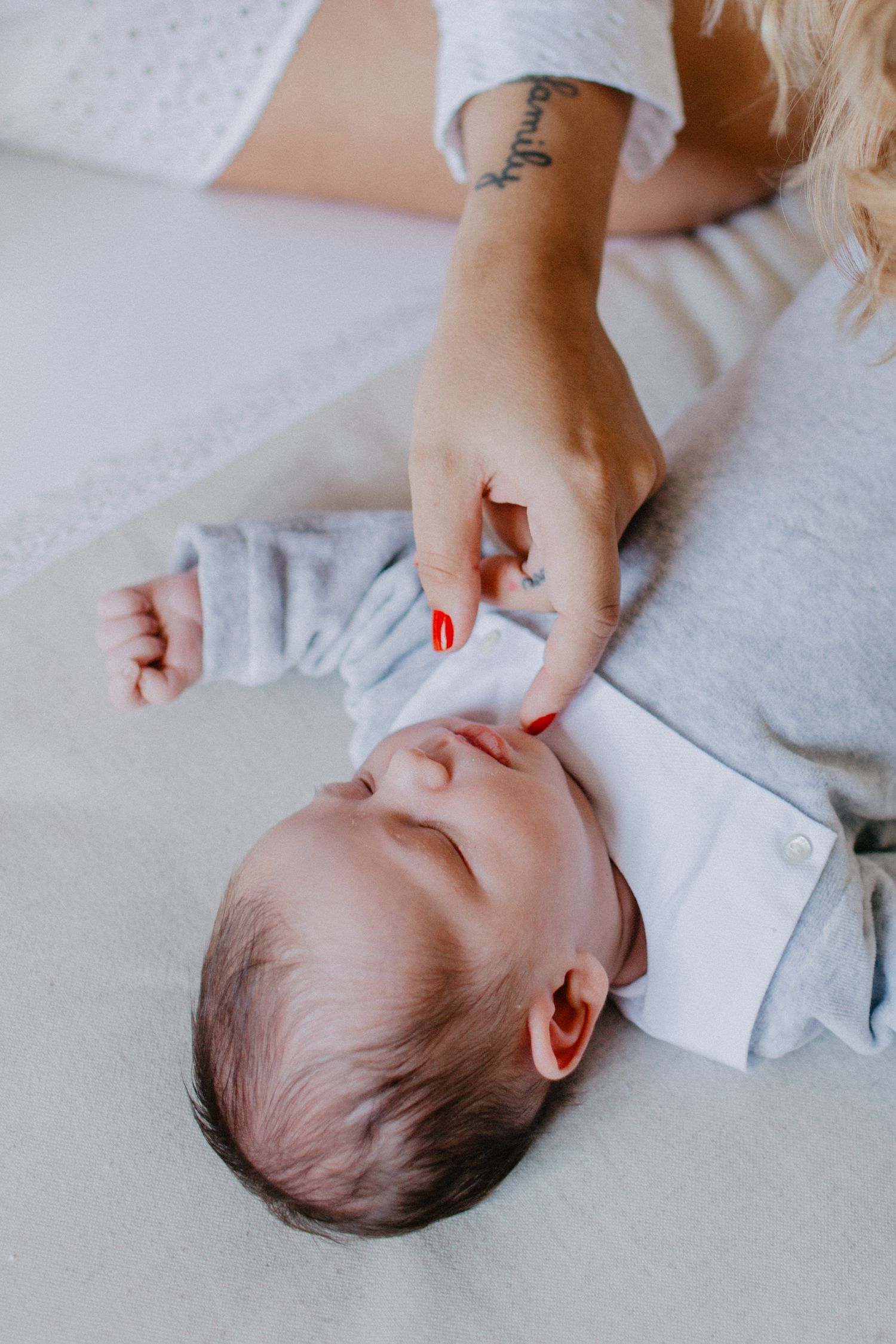 Close-up shots of a baby lying on white bedding.