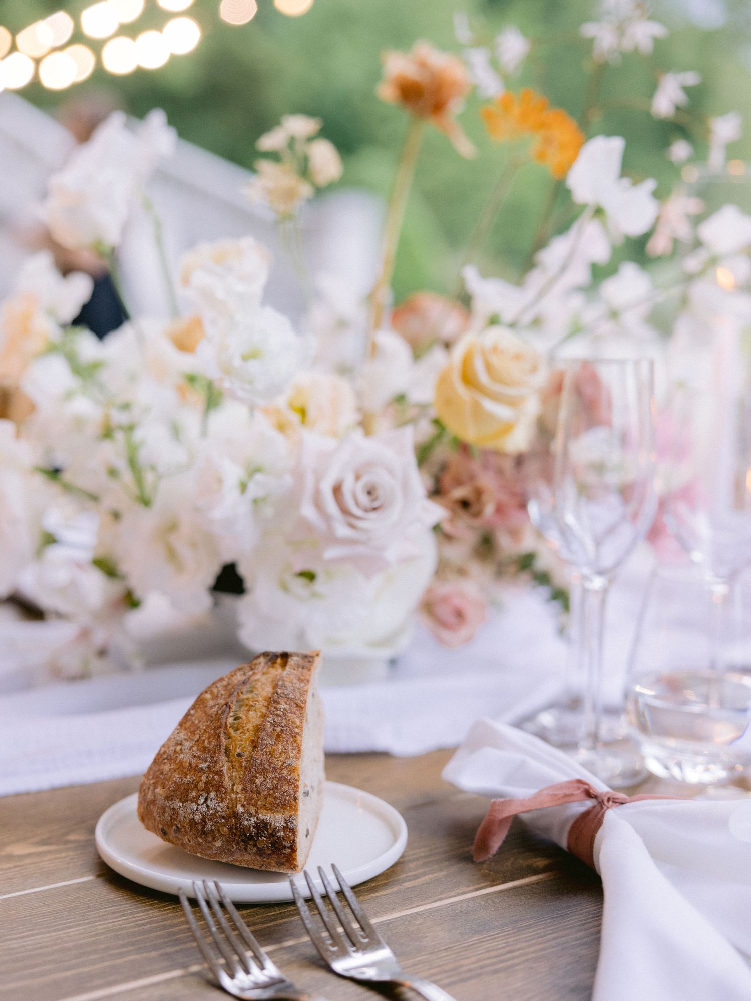 Elegant table setting with floral decorations and dessert plates at a wedding reception.