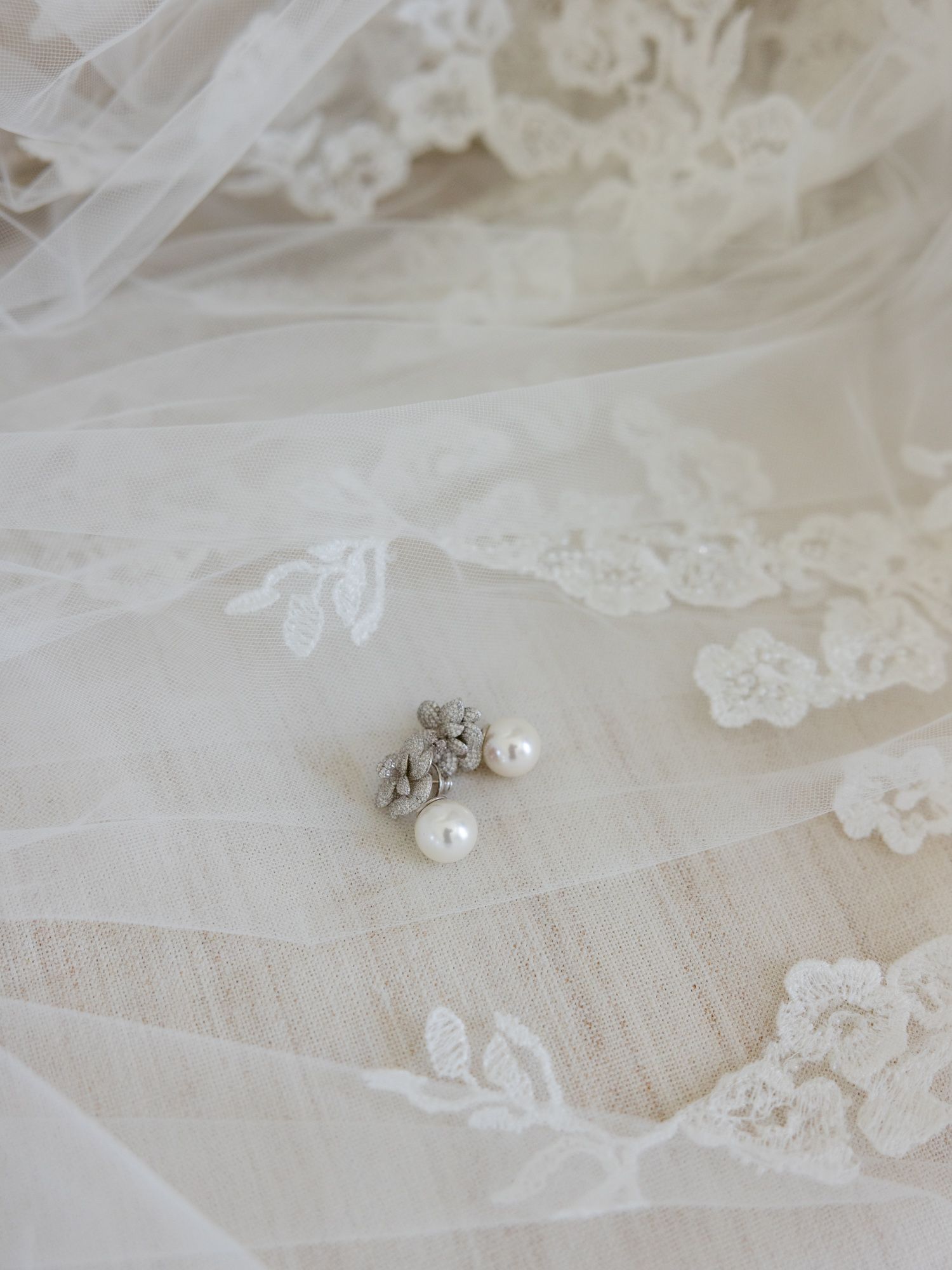 Delicate white lace fabric with pearl details from a wedding dress.