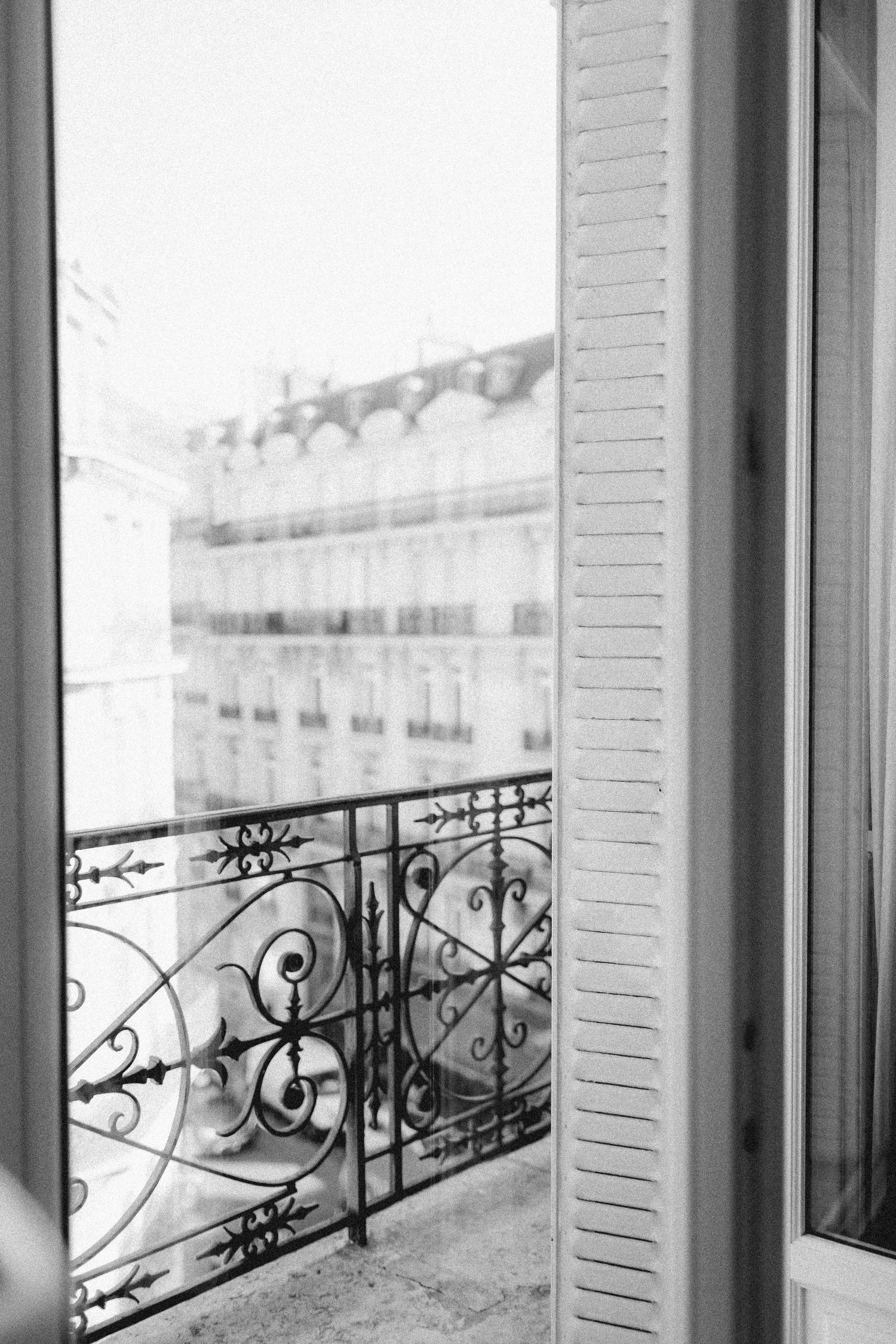 Elegant wrought iron balcony railing with decorative scrollwork patterns in black and white.