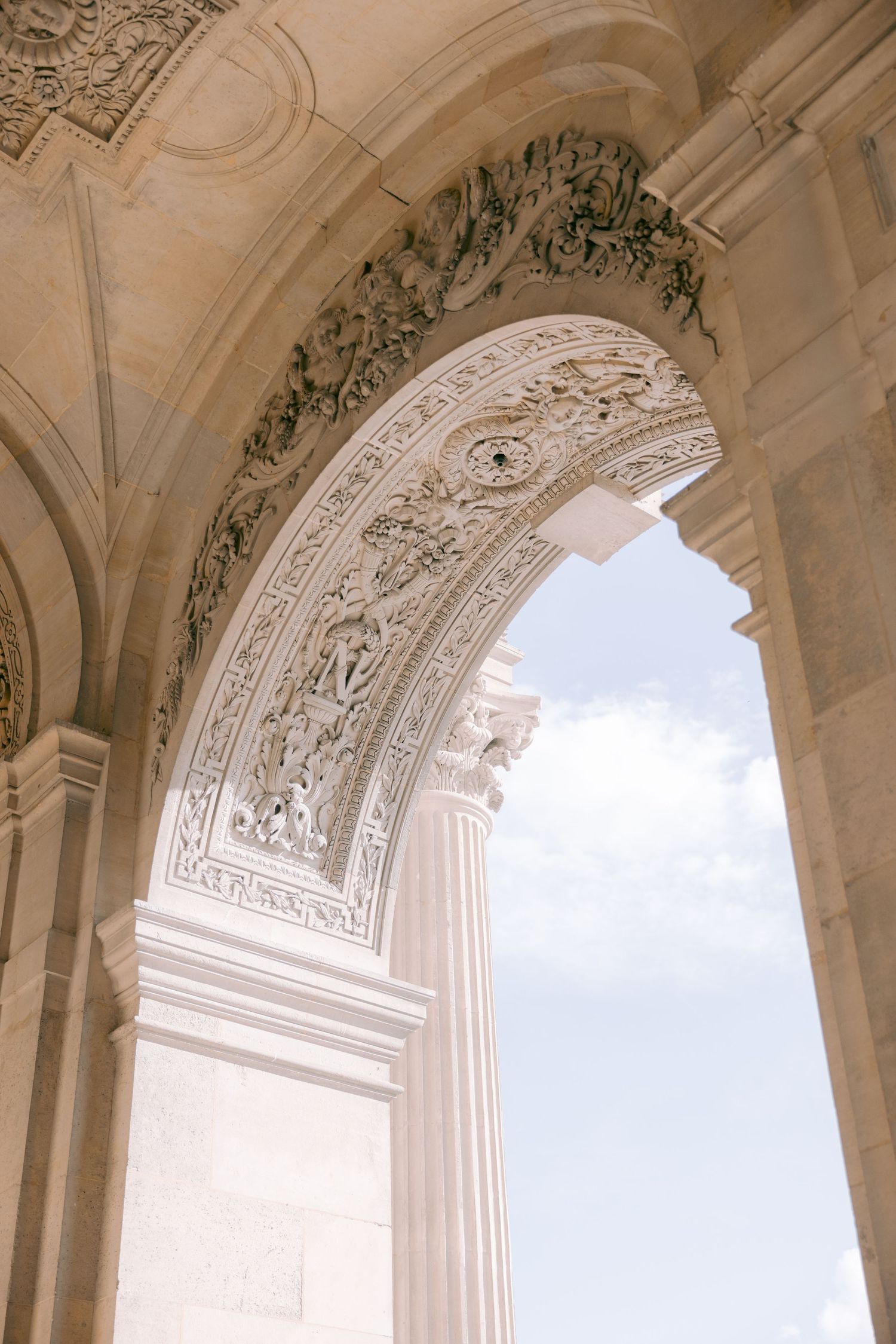 Ornate architectural details of a classical stone archway with decorative carvings and moldings.