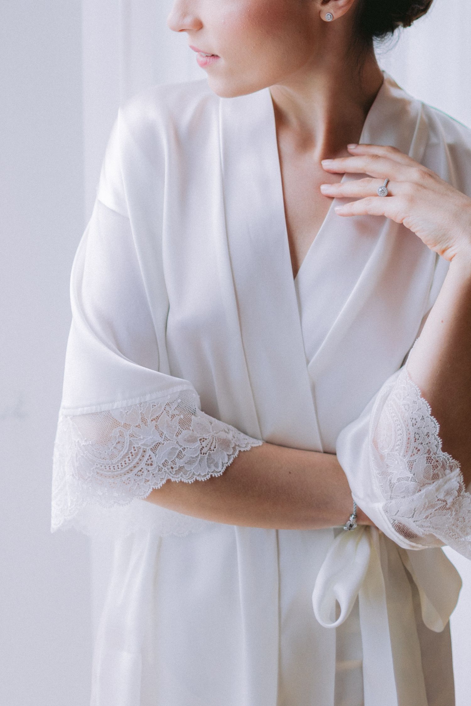 Delicate white lace trim detail on the sleeve of a bridal robe.