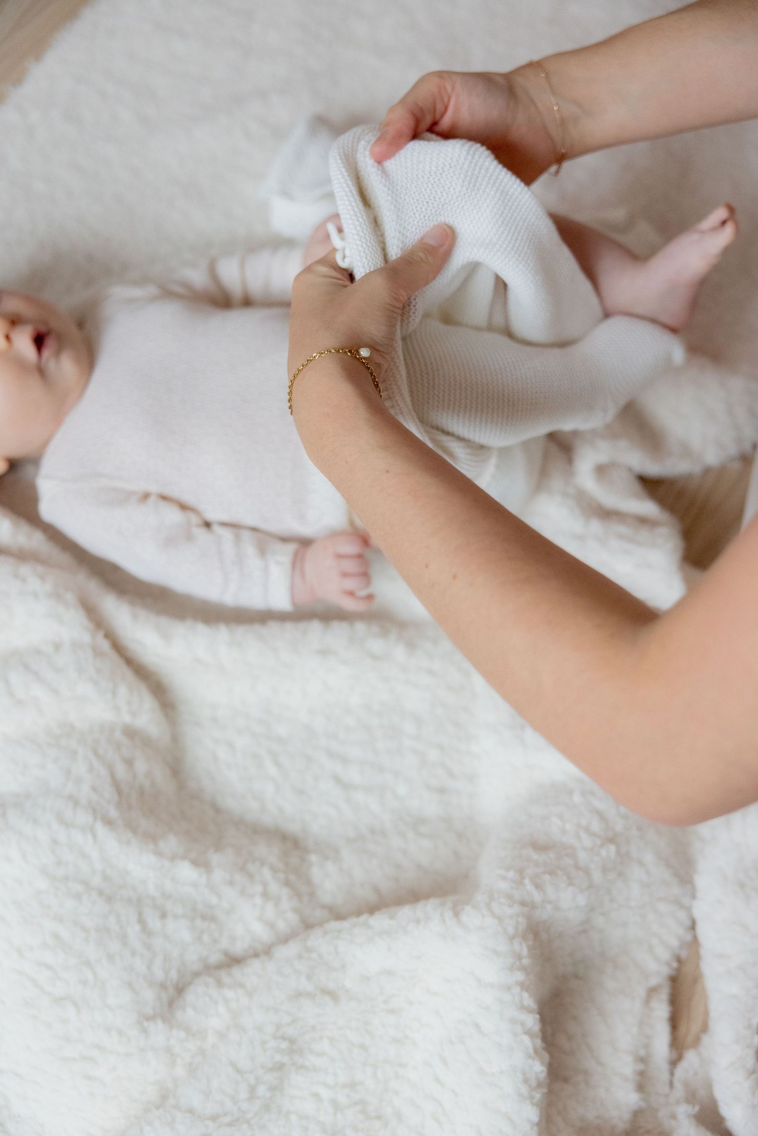 Series showing gentle hands arranging soft white fabric on textured surface.
