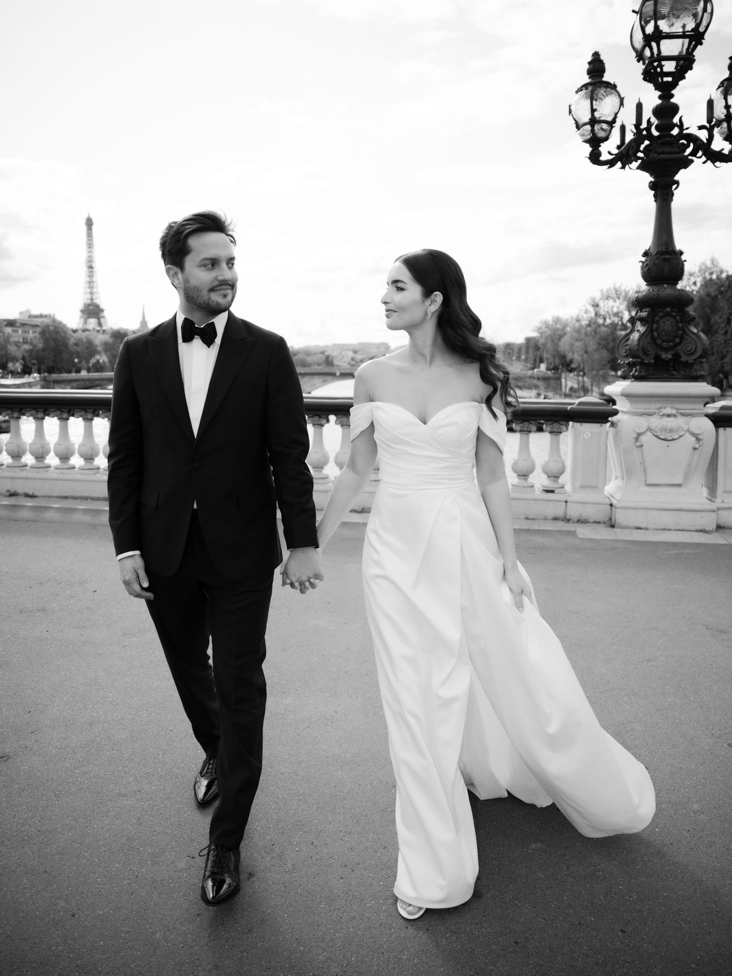 Black and white photo of a couple walking along a grand outdoor terrace.