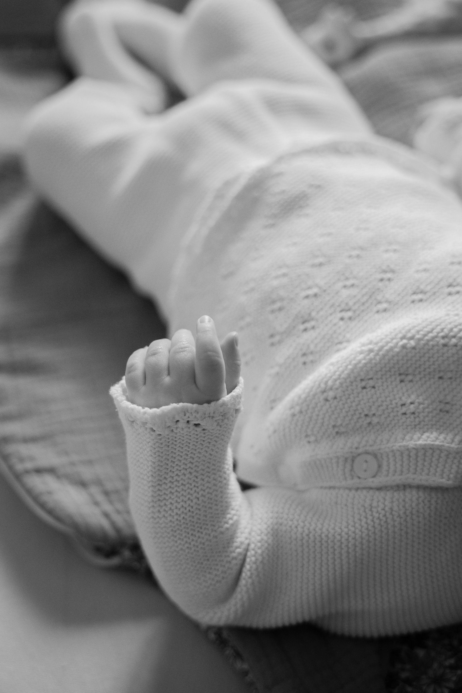 Close-up sequence of white baby socks on a soft surface.