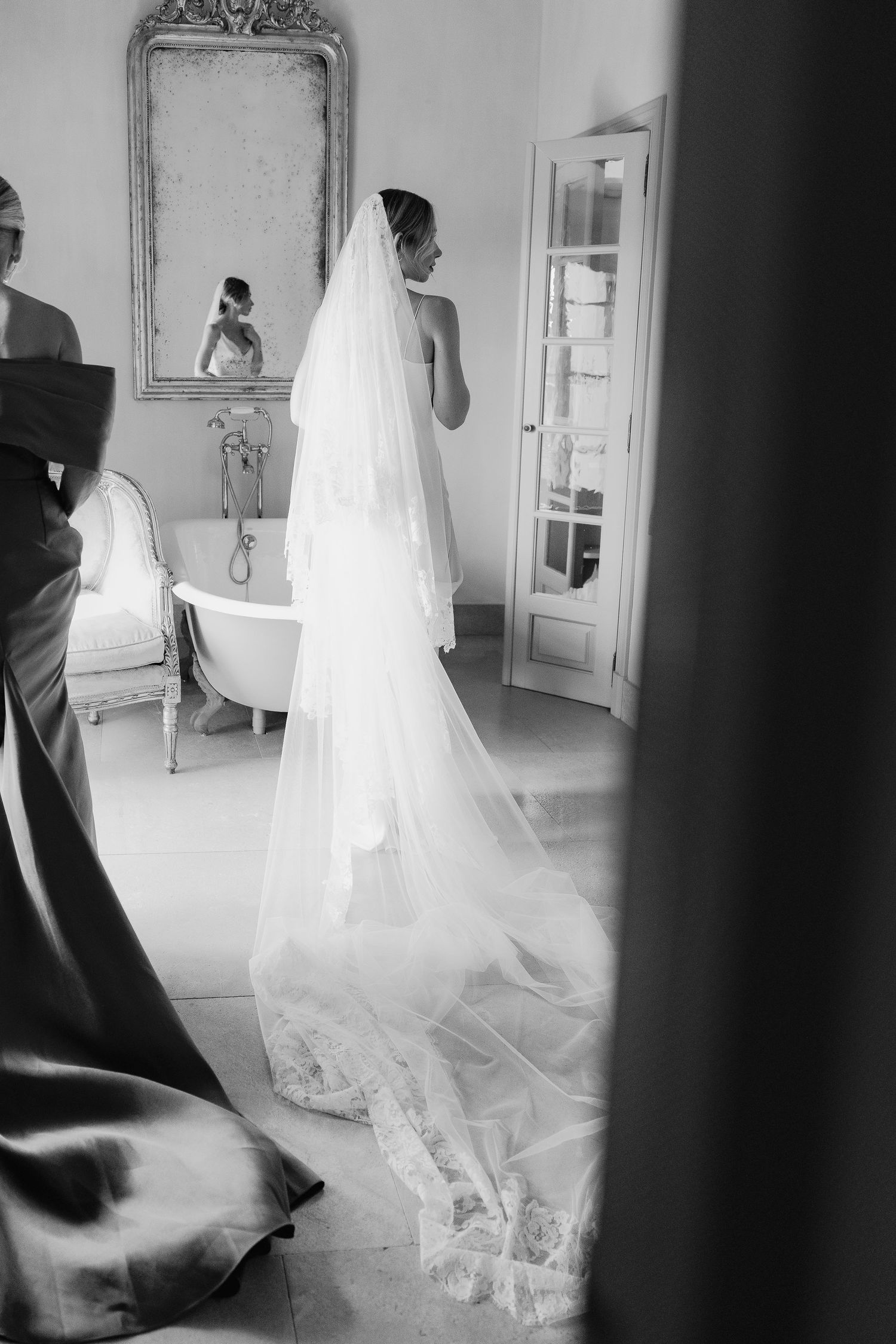Artistic black and white capture of flowing wedding dress and veil movement.