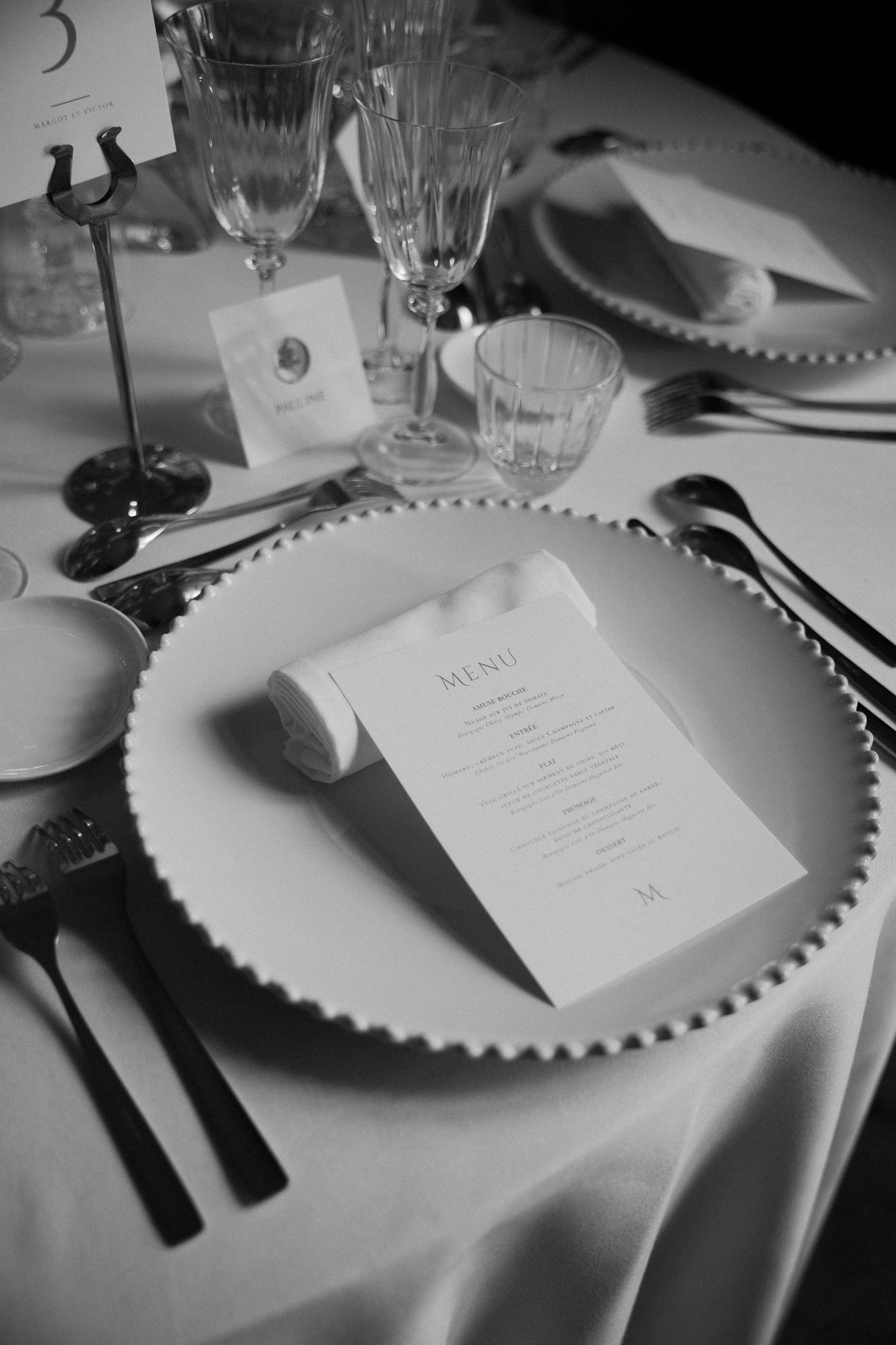 Elegant black and white table settings with menu cards at a formal wedding reception.
