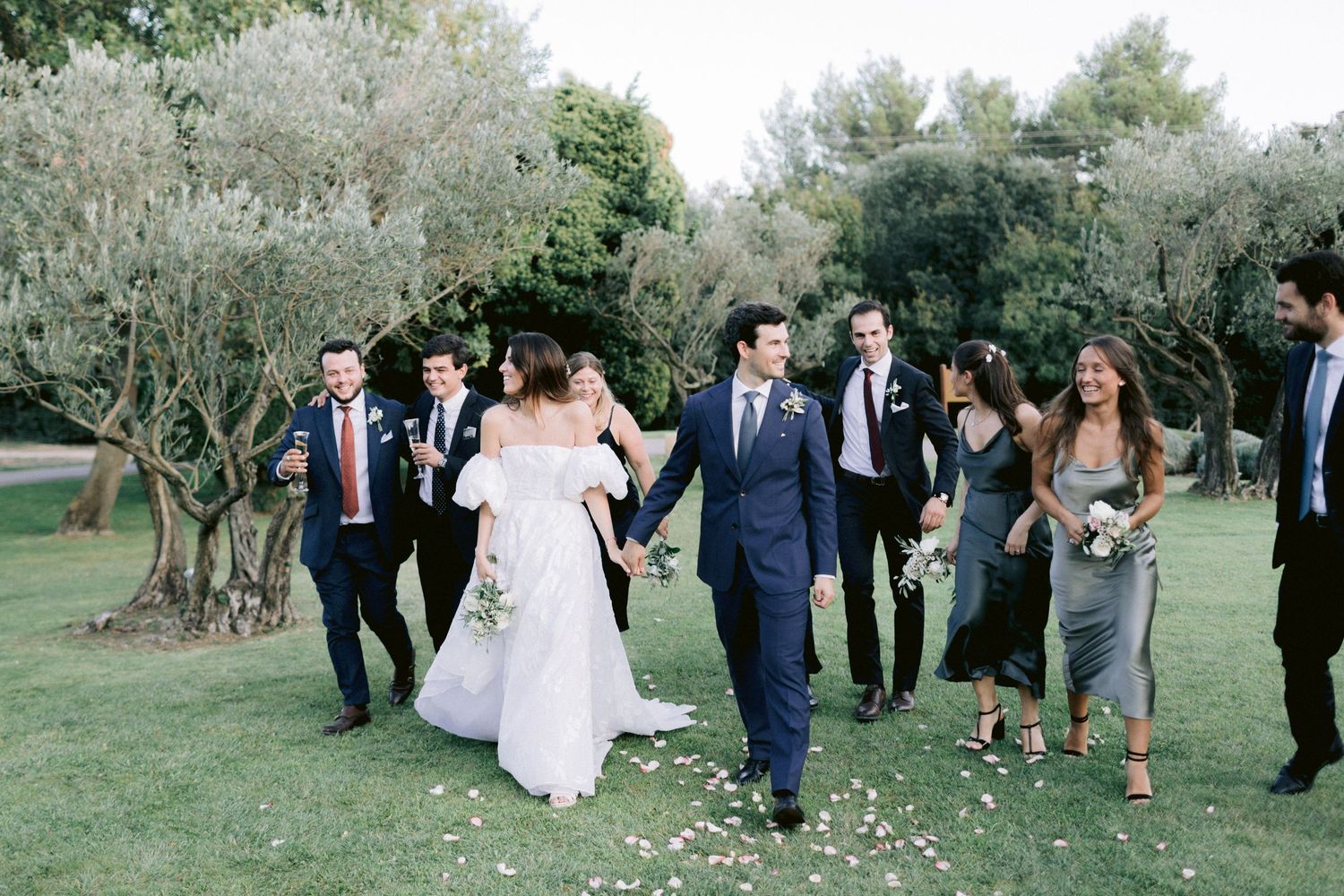 Wedding celebration with guests walking through an outdoor garden venue.