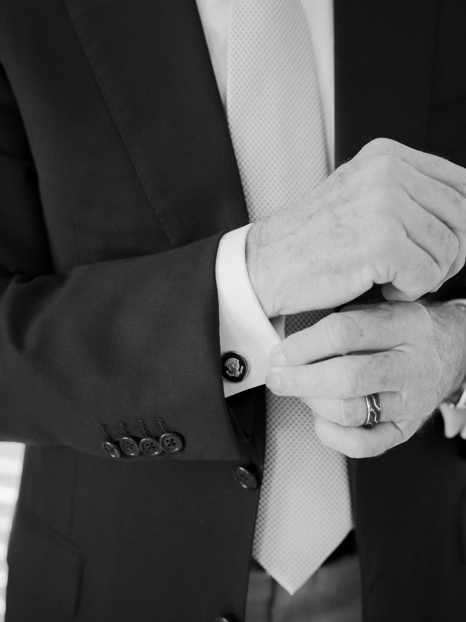 Close-up of formal black suit jacket buttons and cuffs in monochrome.