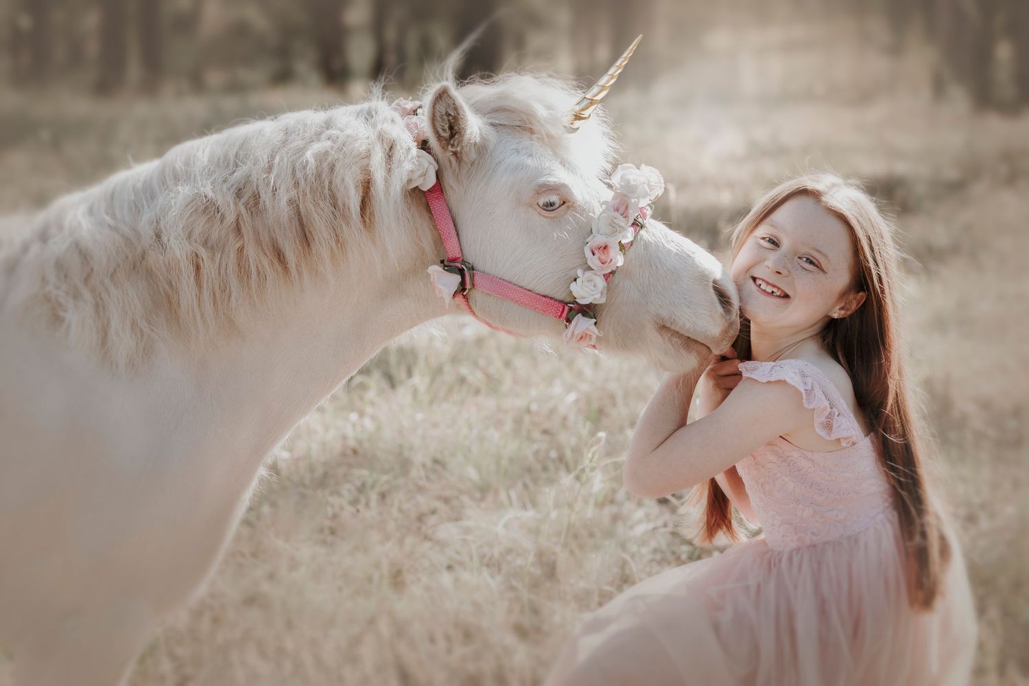 A playful moment with a white horse wearing pink tack in a natural setting.