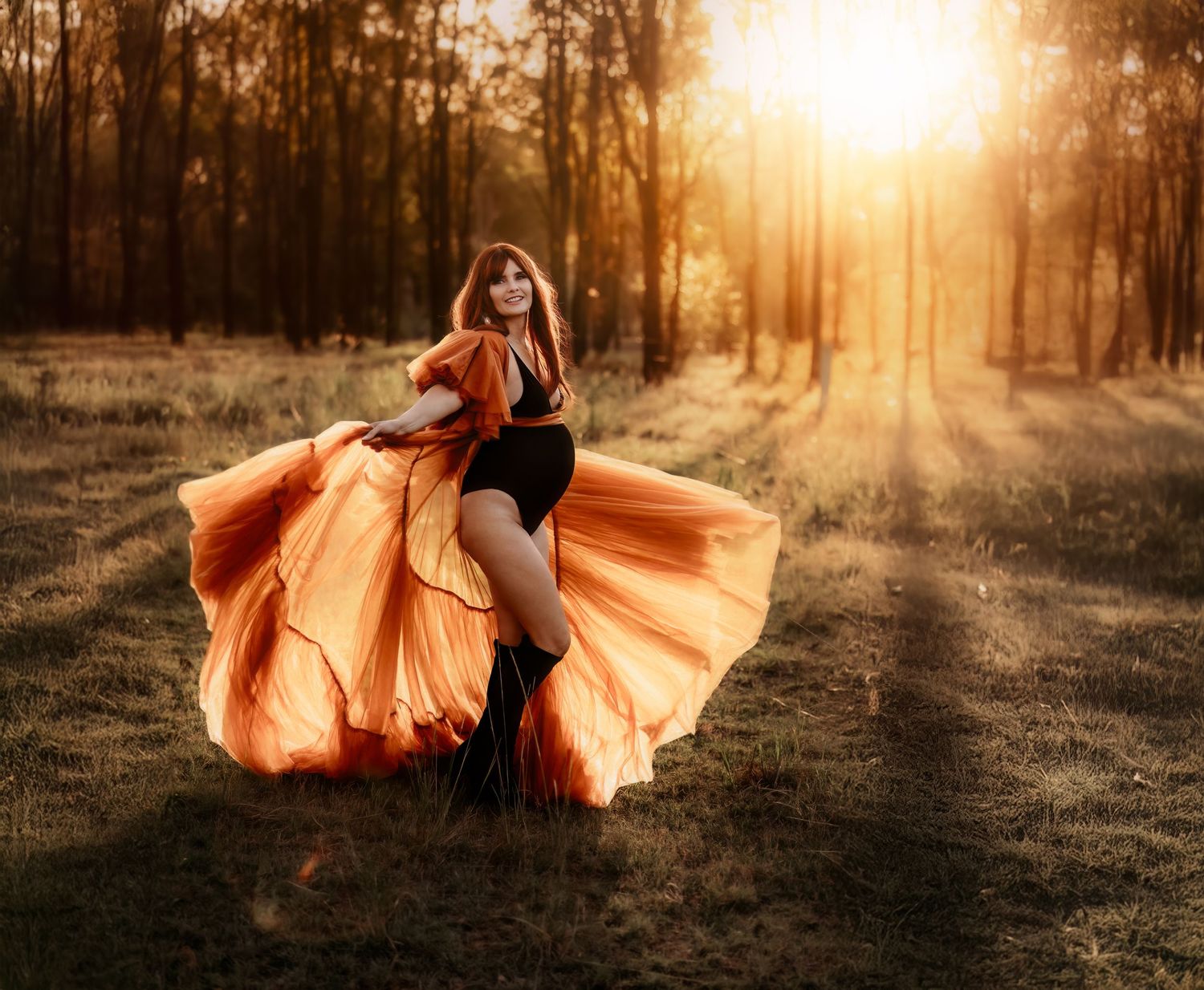 Flowing orange dress twirls dramatically in golden sunset light through autumn forest clearing.