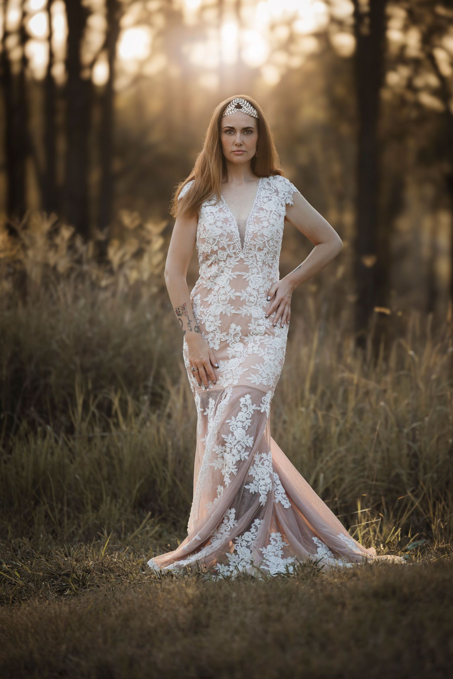 A delicate white lace dress flows gracefully in a golden-lit field during sunset.