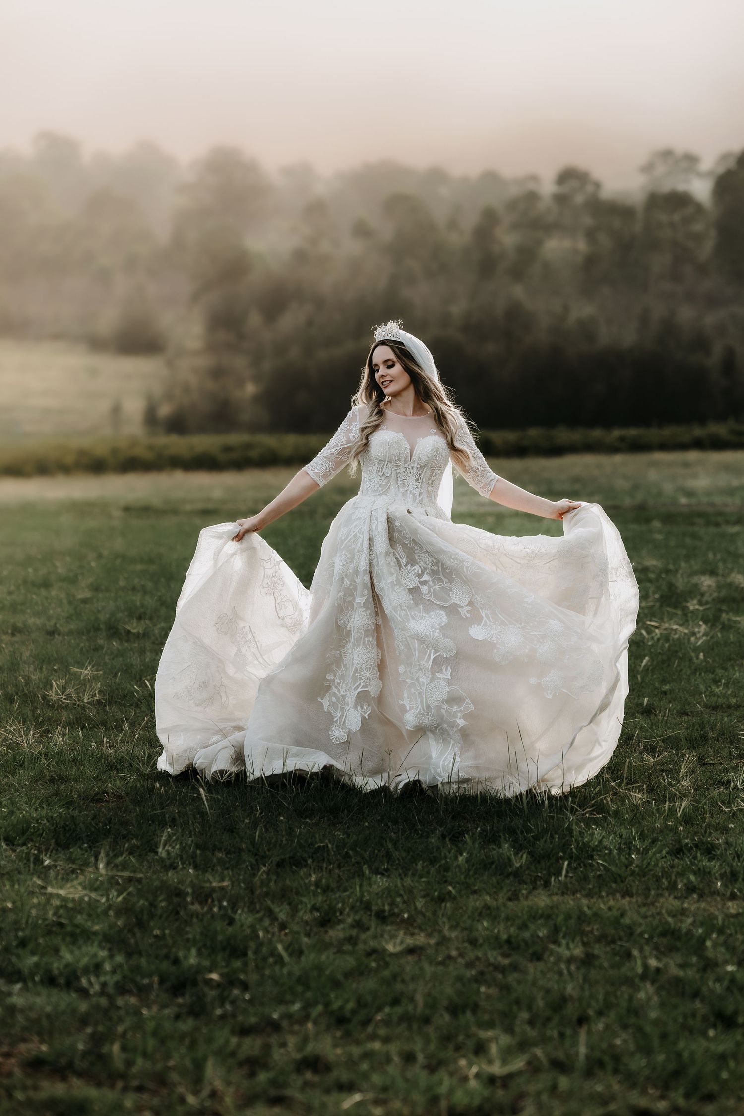 Beautiful white wedding dress billowing in the wind as the wearer stands in a serene meadow.