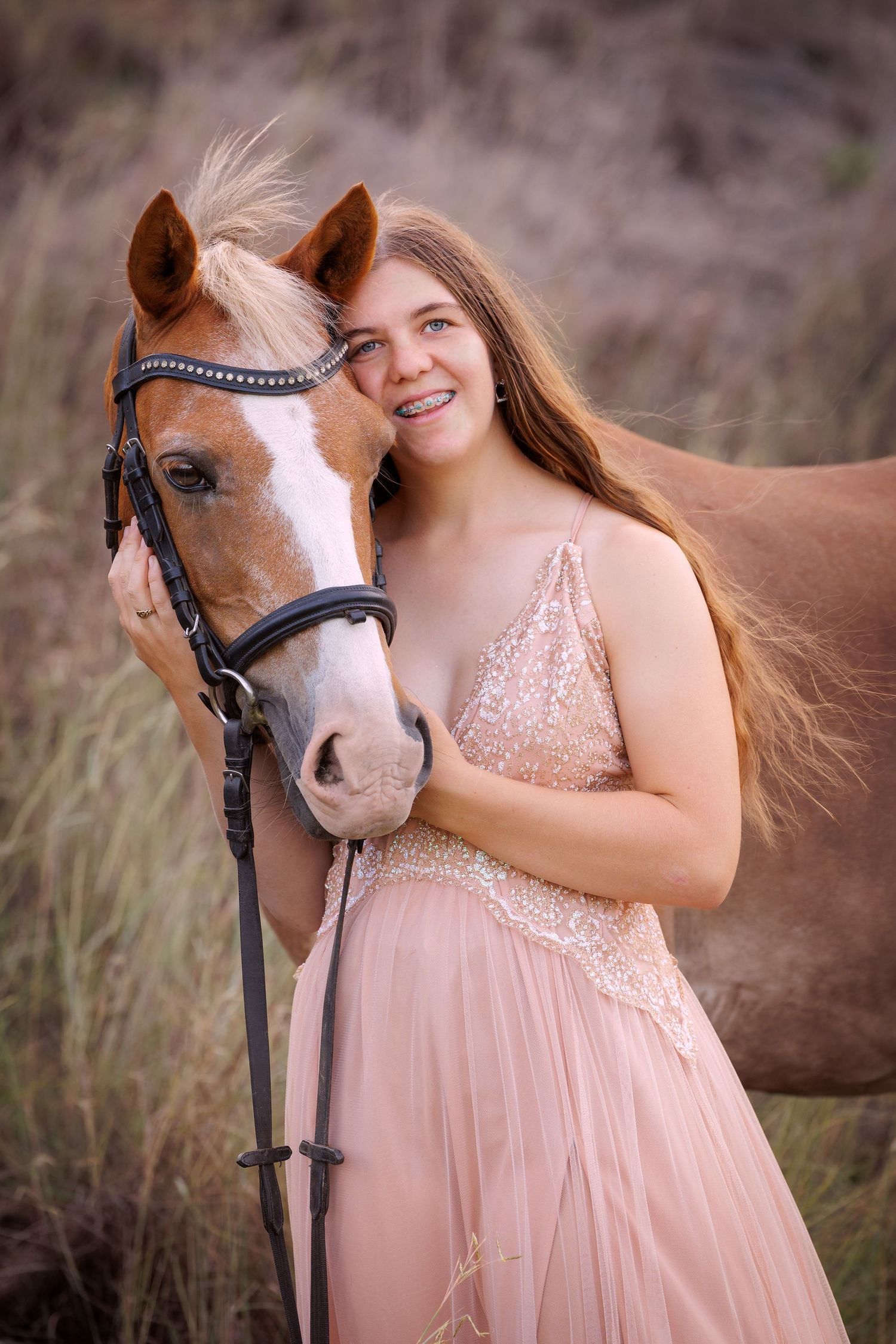 A chestnut horse and elegant pink sparkly dress create a romantic outdoor portrait.
