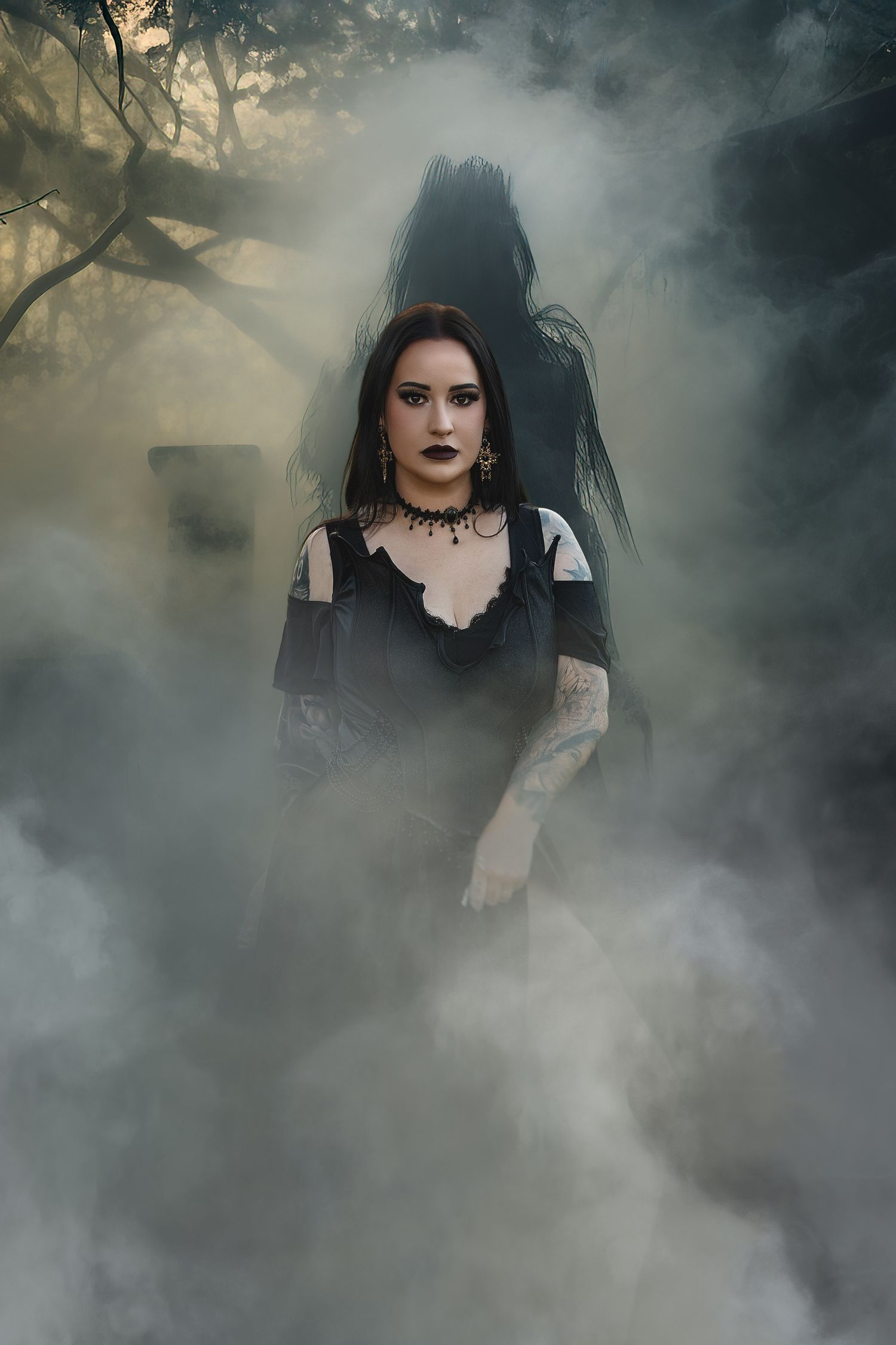 A gothic figure in a black dress stands mysteriously in atmospheric fog and mist surrounded by dark trees.