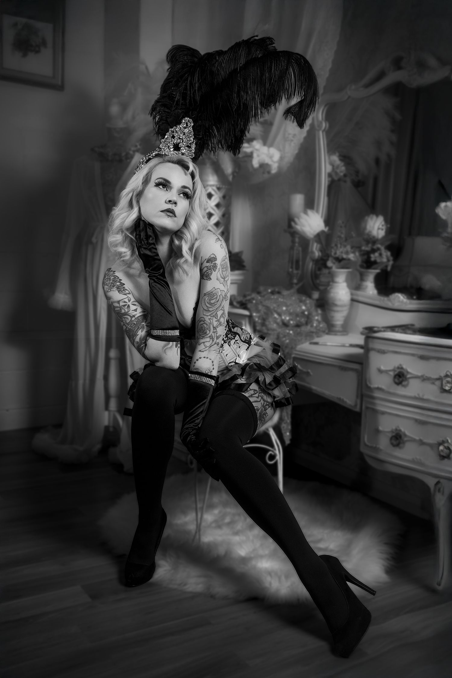 Artistic black and white photo series showing a woman in dark clothing posing dramatically on a chair in a vintage room.