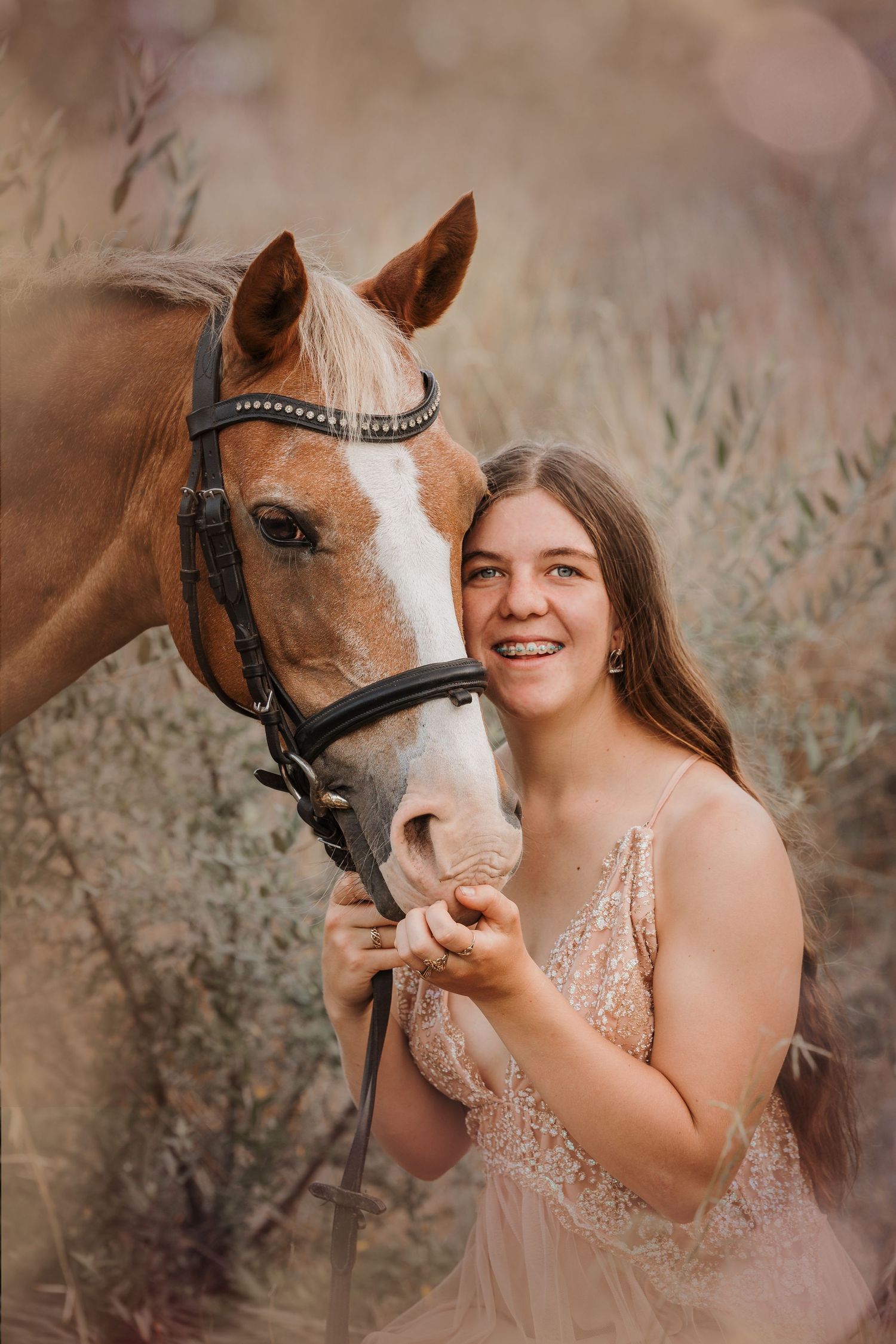 A dreamy portrait with a chestnut horse and someone wearing a sparkly pink dress in soft lighting.