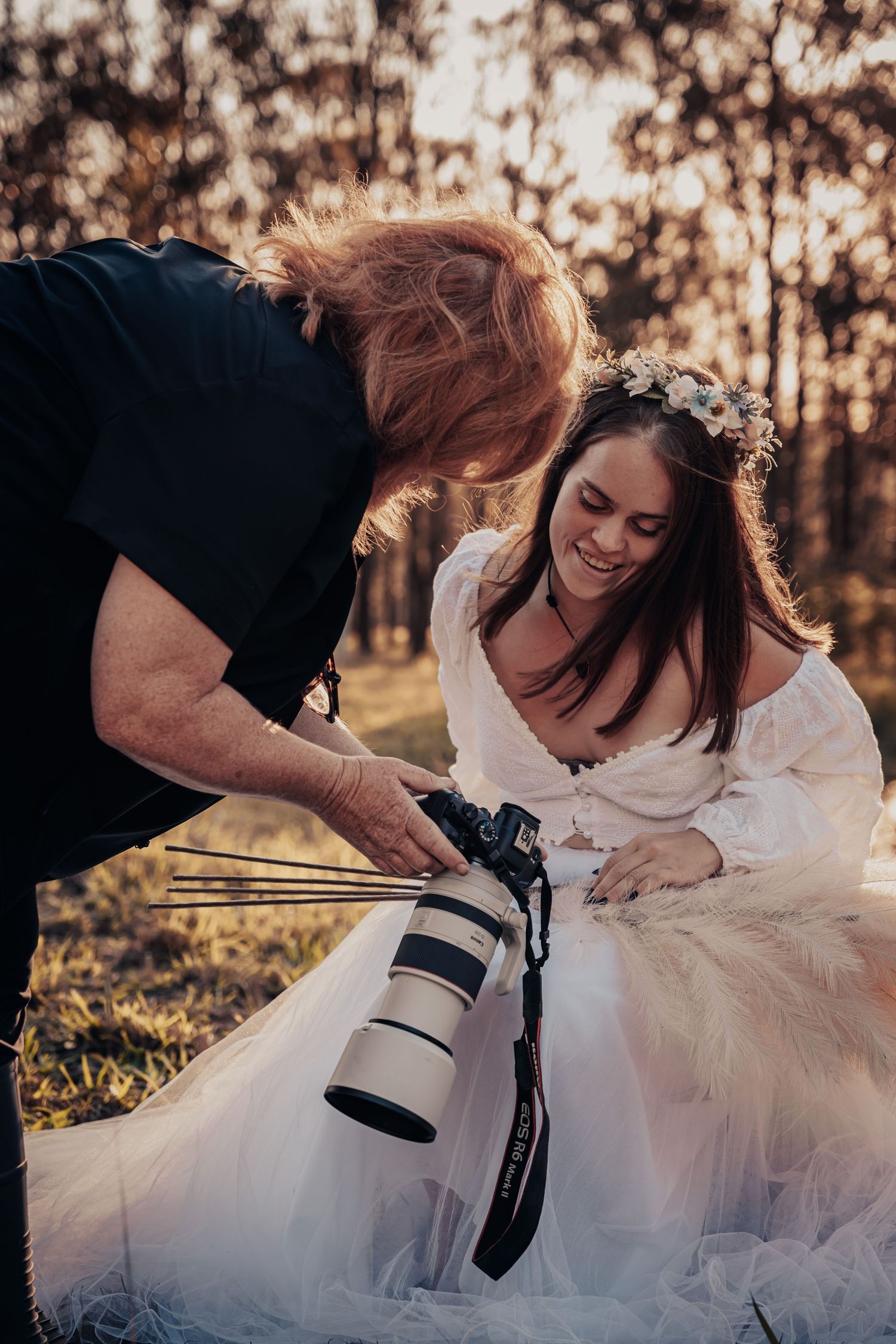 A candid moment between photographer and subject reviewing images during an outdoor photoshoot.