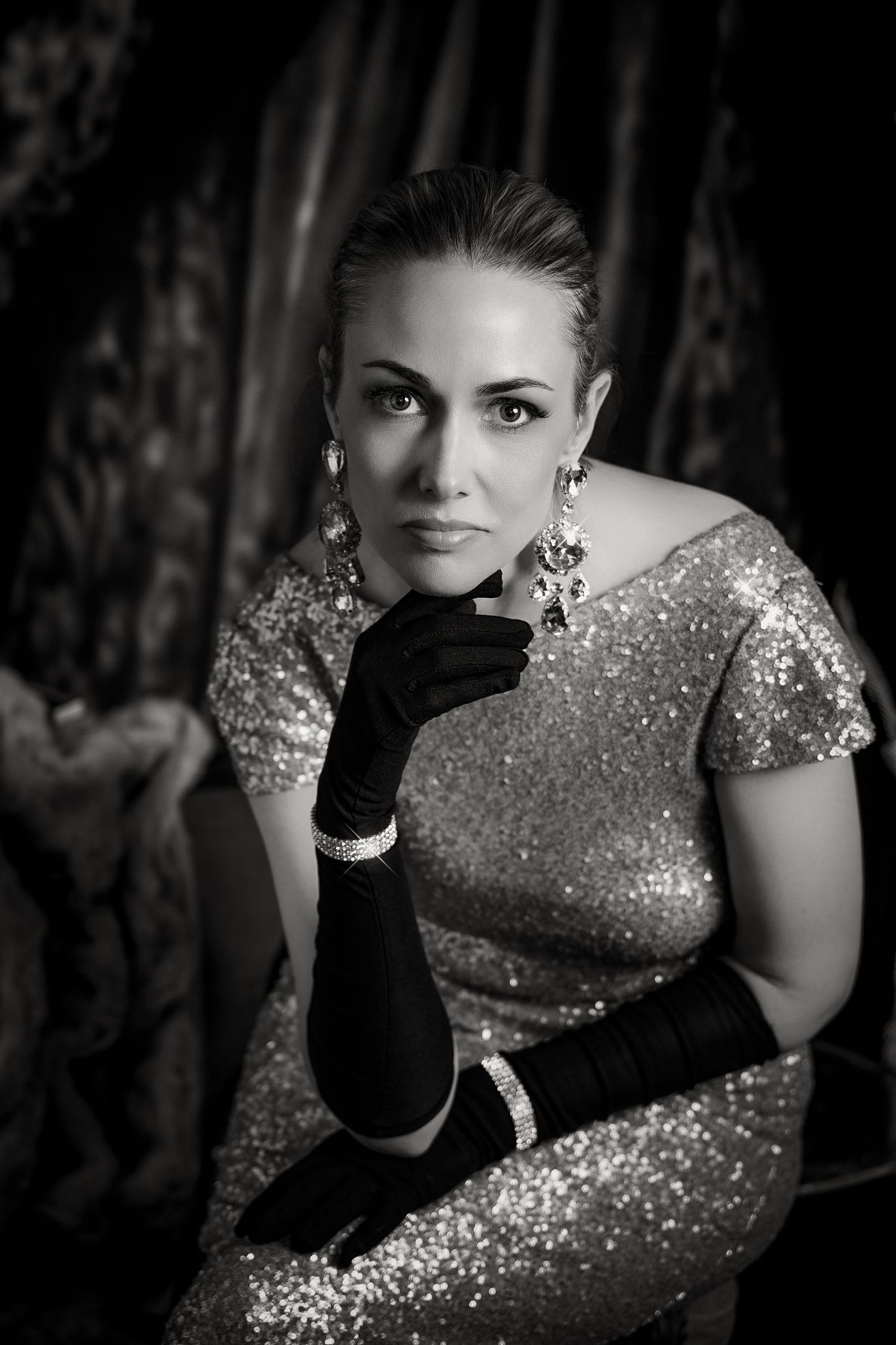 Black and white portrait series showing a figure in a sequined dress and long gloves striking glamorous poses.