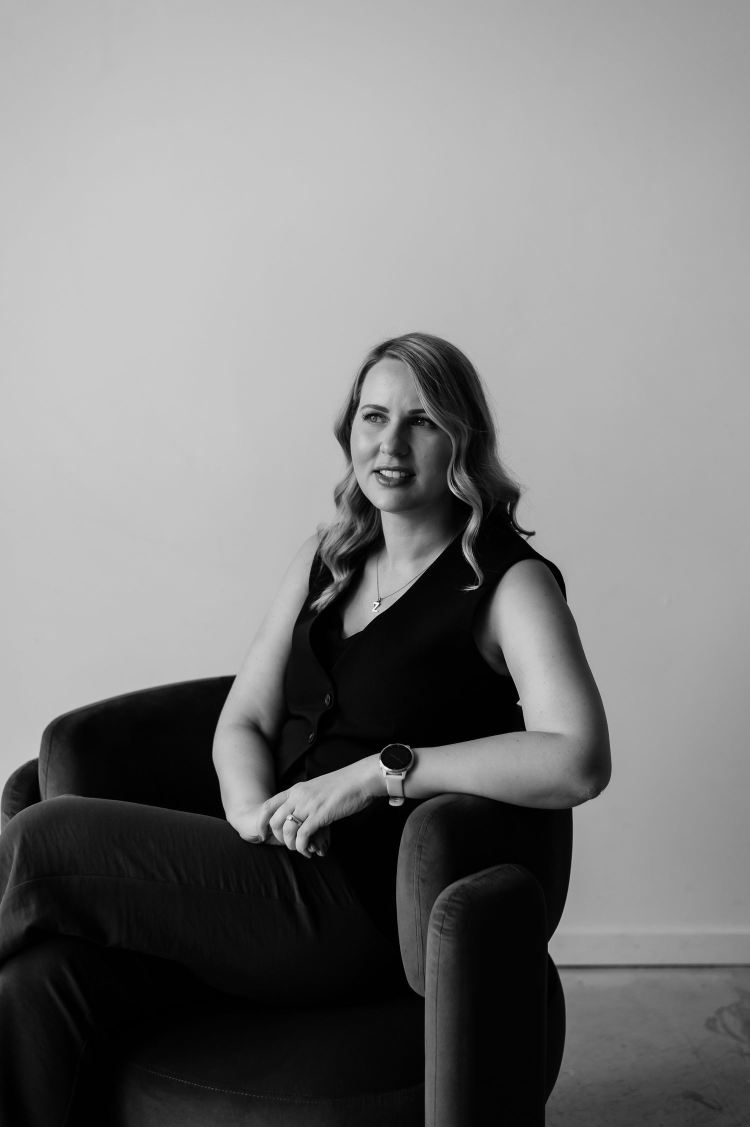 A series of black and white portraits showing a person in a black sleeveless dress posing on a chair against a light background.