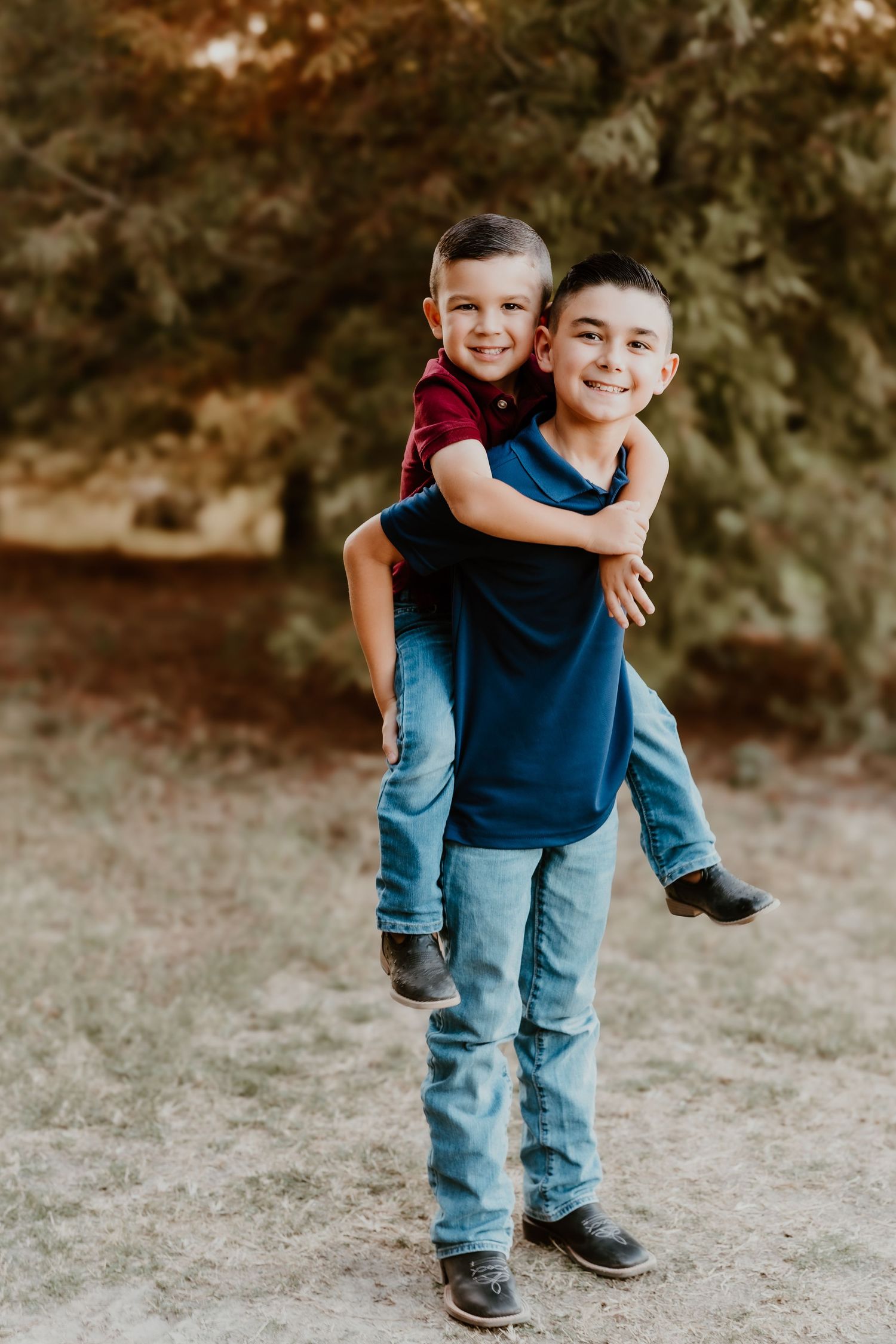 Two children playing and hugging outdoors in a natural setting.