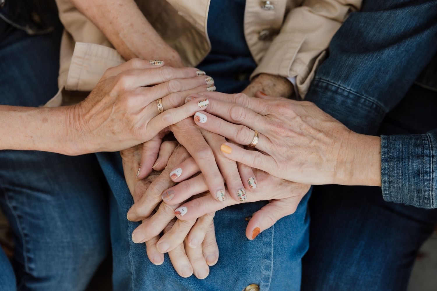 Close-up view of hands clasped together showing wedding rings and intimate connection between a couple.