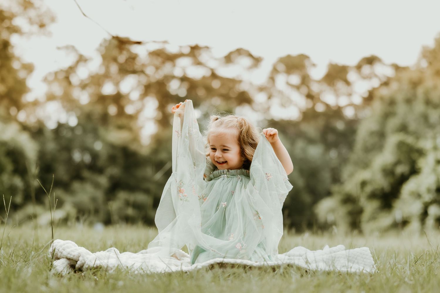 Whimsical outdoor portrait series in a mint green dress among tall grass.