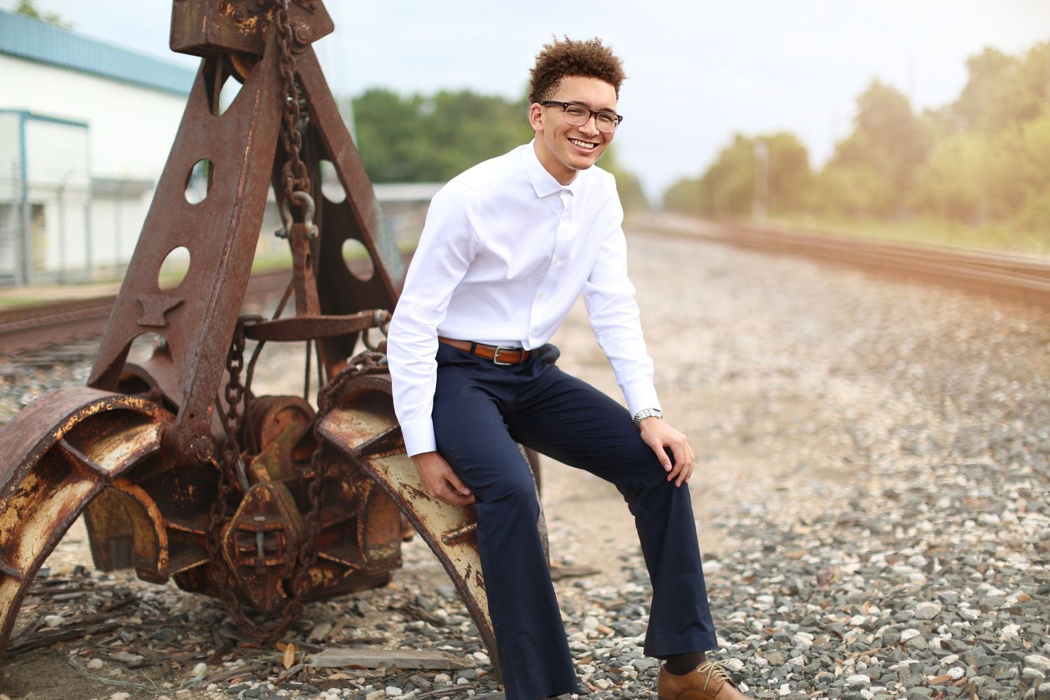 Person in formal attire posing near vintage railroad equipment.
