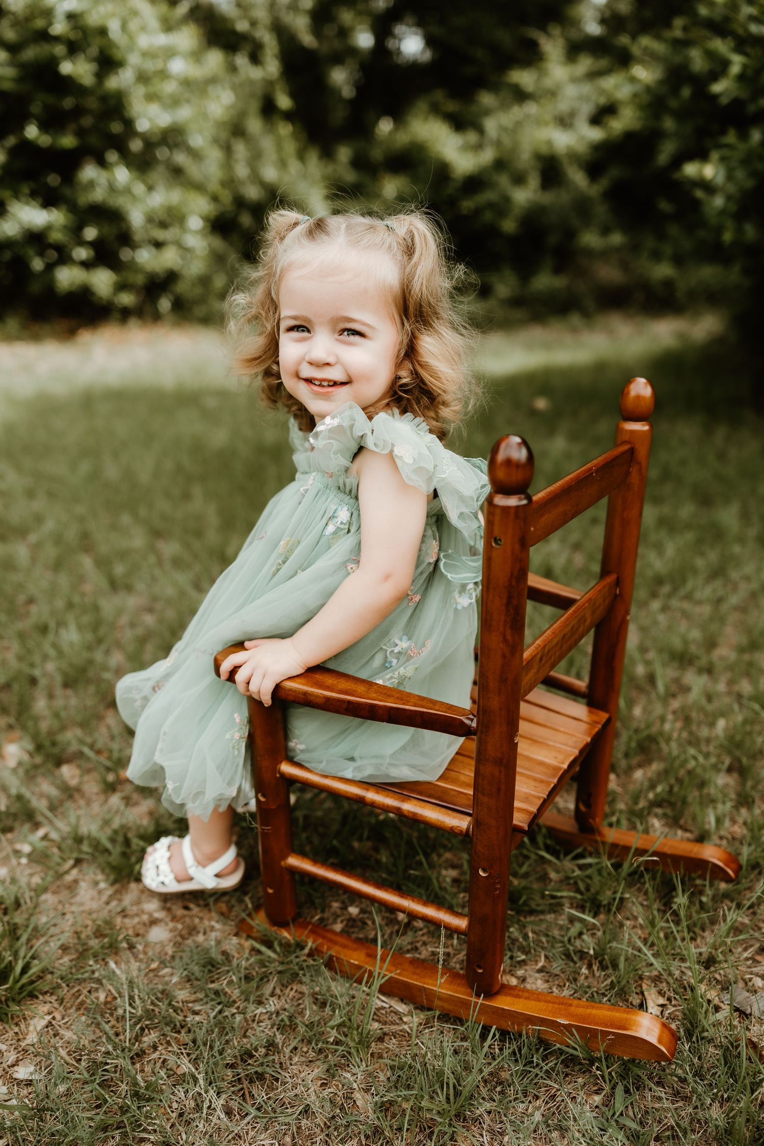 Playful moments captured on a wooden chair in a sunny garden setting.