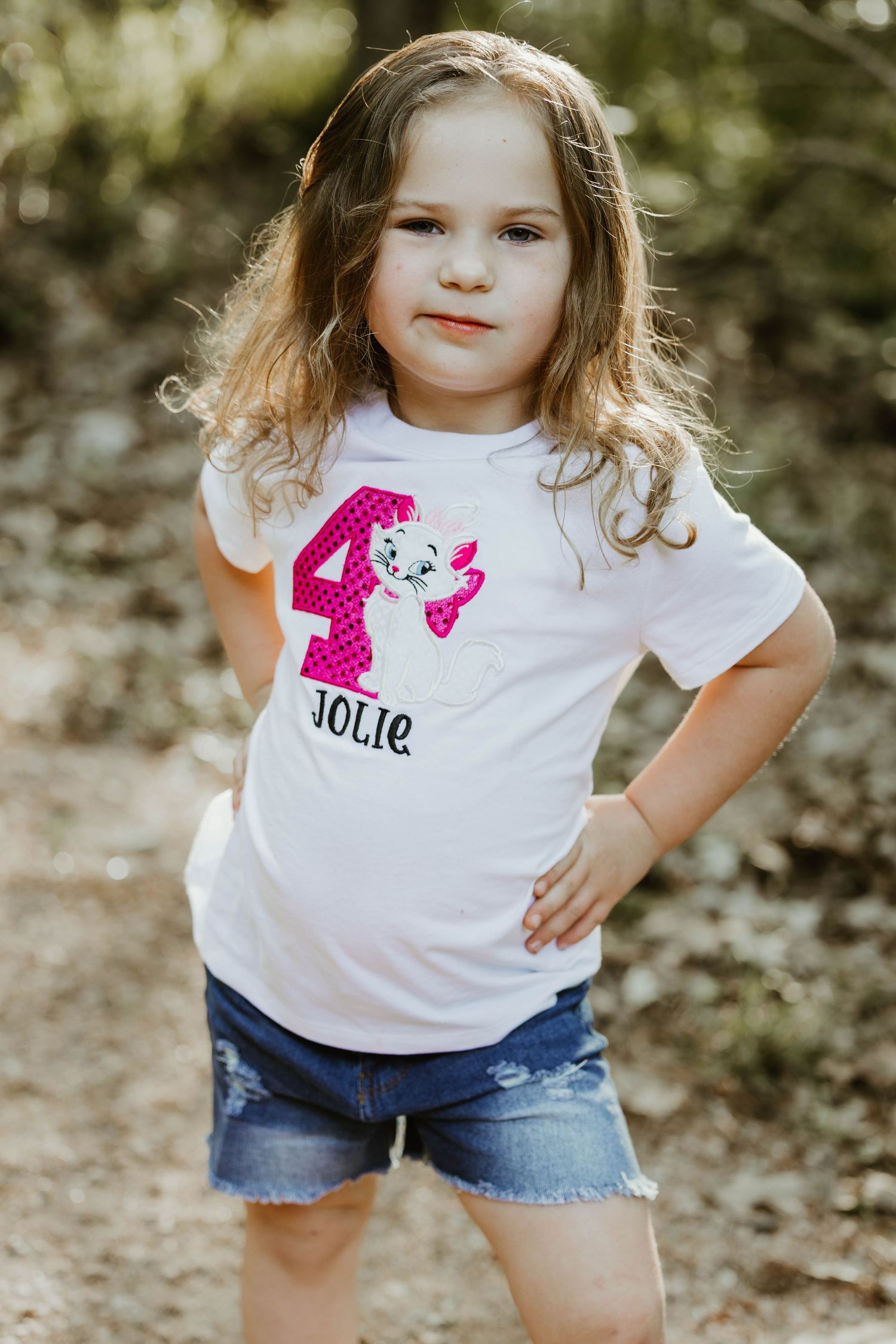 Young child wearing custom t-shirt with pink number design poses confidently outdoors.
