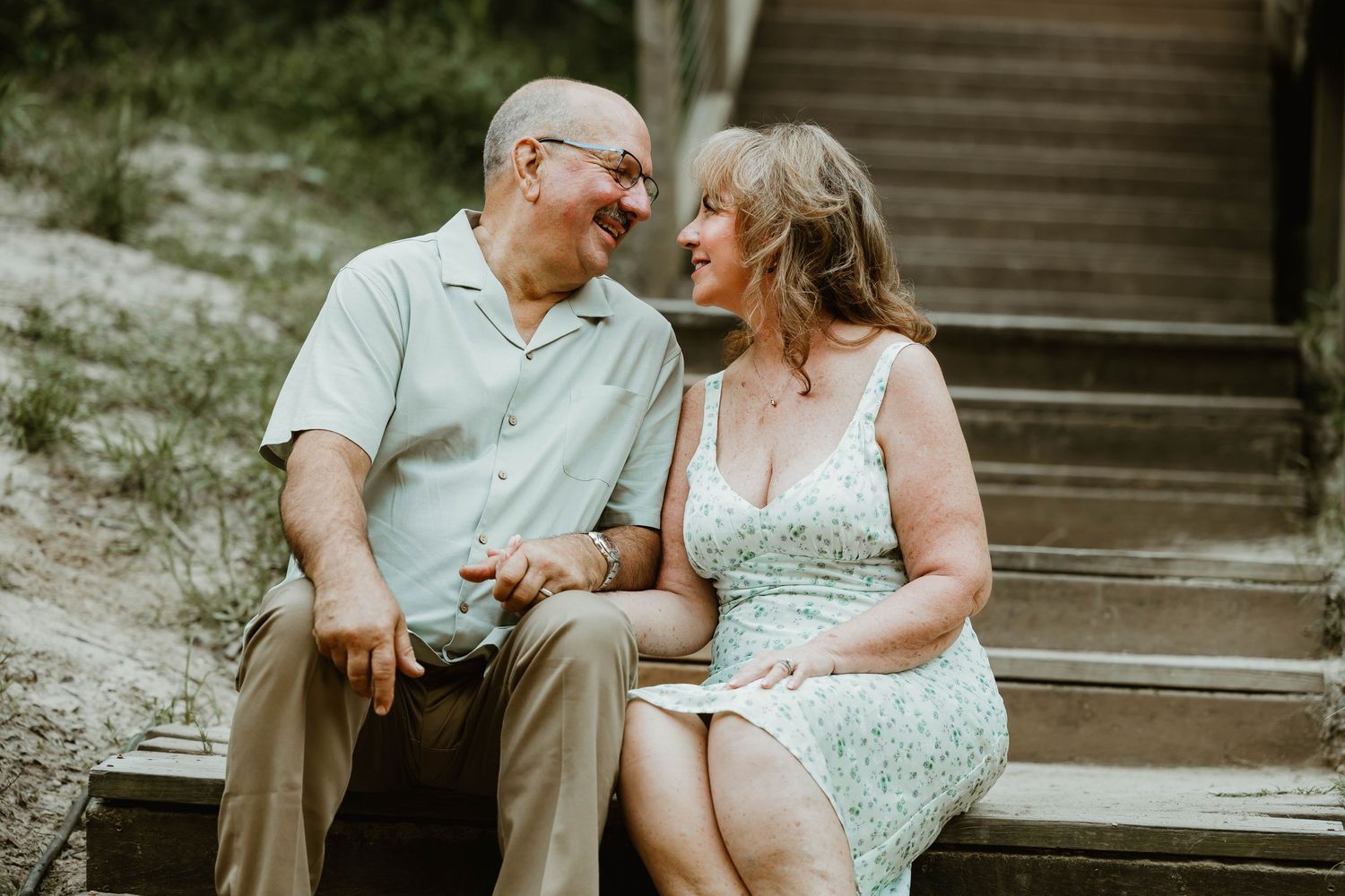 Couple sitting together on wooden steps sharing intimate moments.