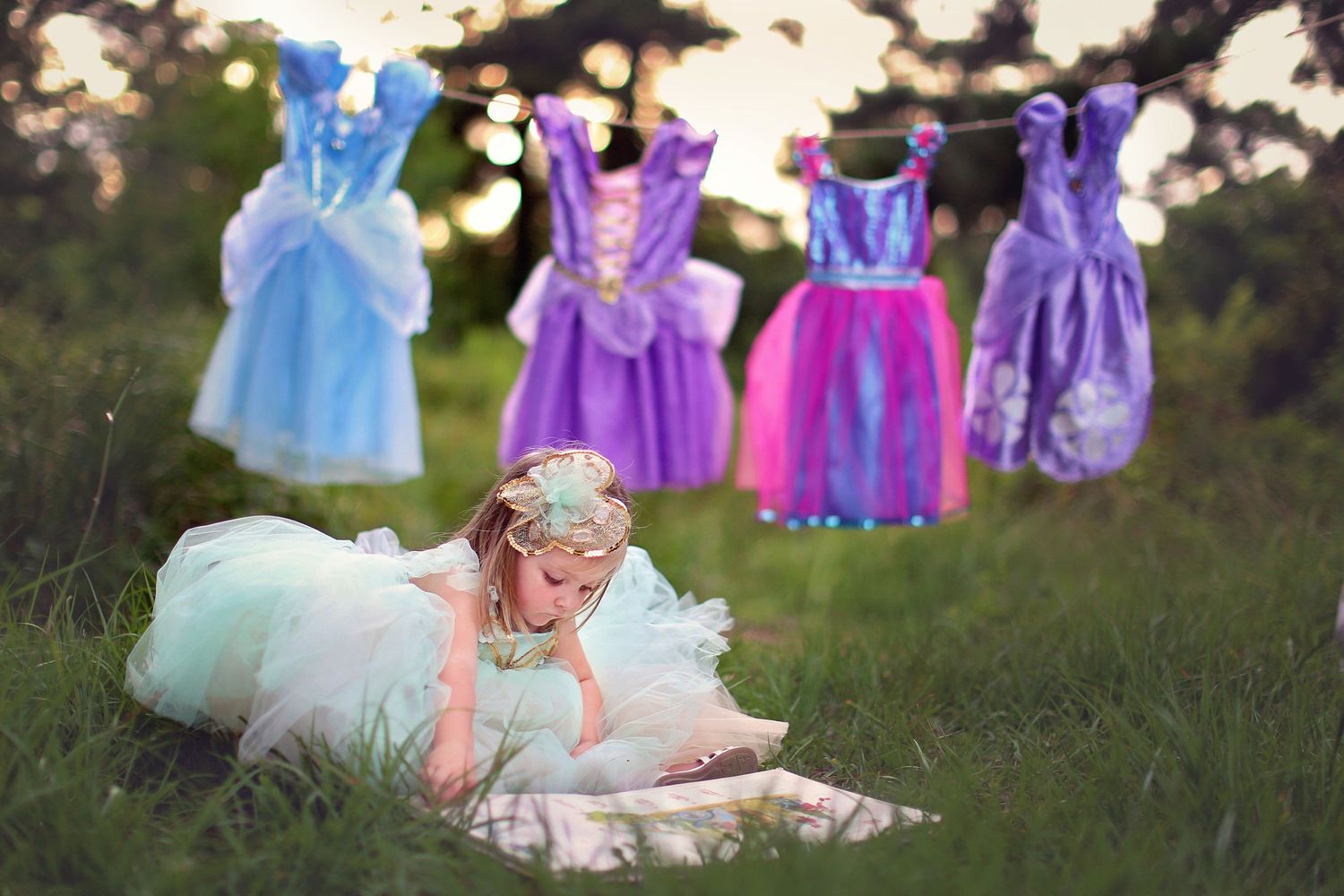 Colorful tulle dresses hanging on a clothesline outdoors against a natural backdrop.