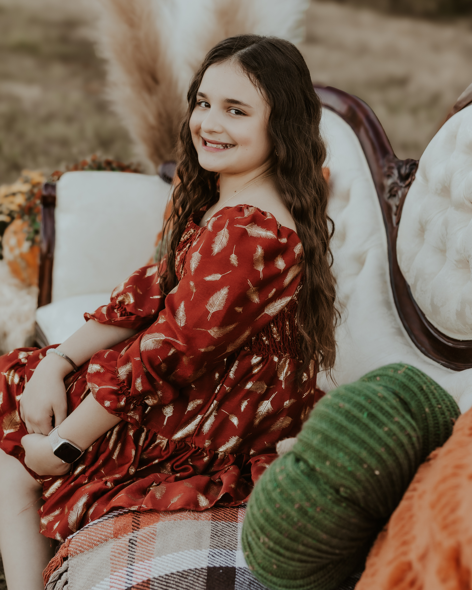 Cozy autumn scene with red dress and green pumpkins on plaid blanket.