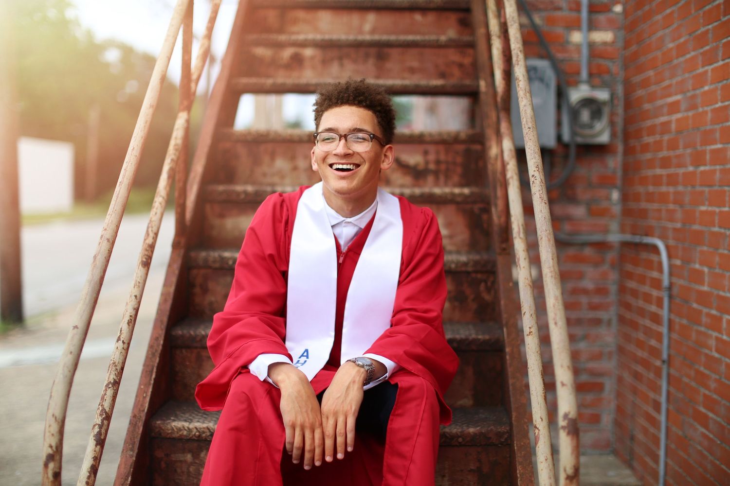 Person in red blazer and white shirt posing on rustic brick steps.