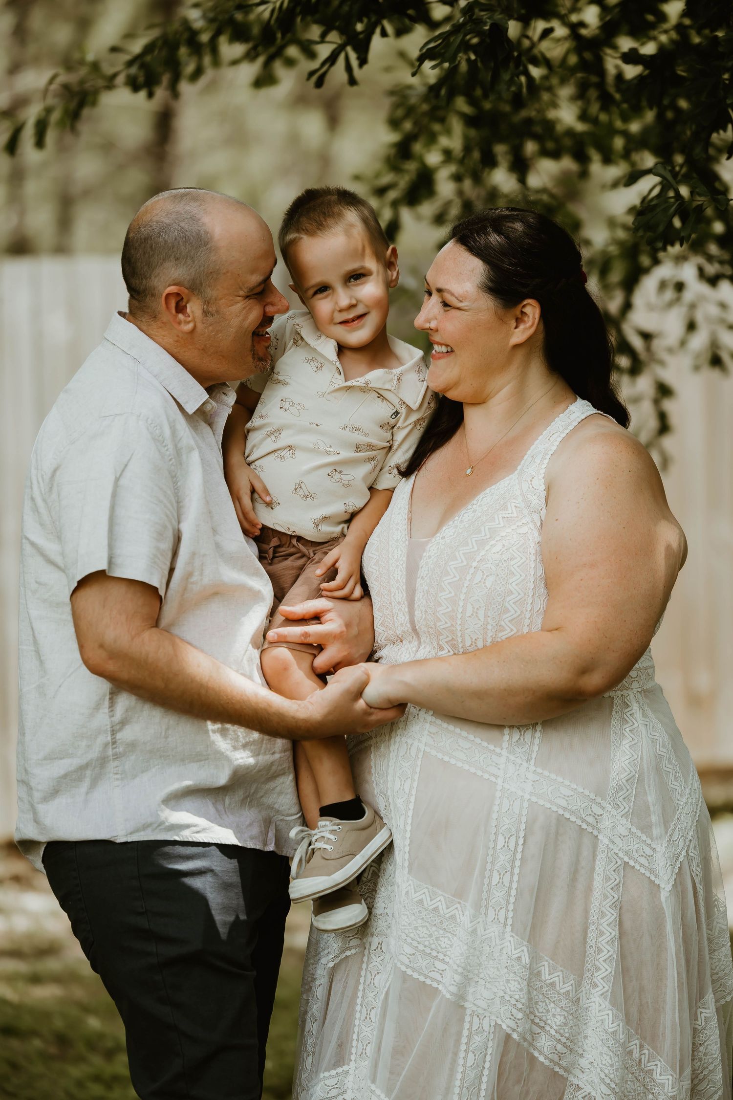 Family portrait session outdoors with soft natural lighting and white summer attire.