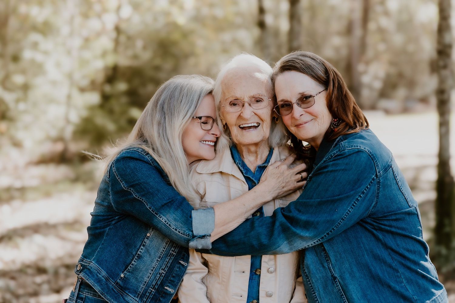 Family members in coordinating blue outfits share affectionate moments during an outdoor photo session.