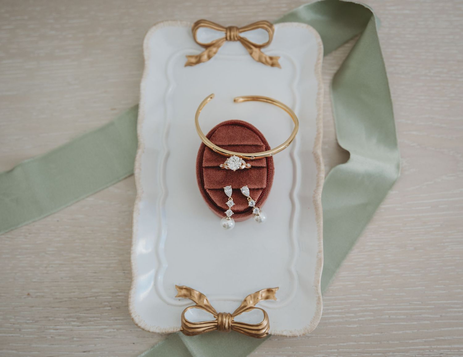 Wedding ring box collection with delicate gold bow designs displayed on white decorative frames for a 30A wedding.