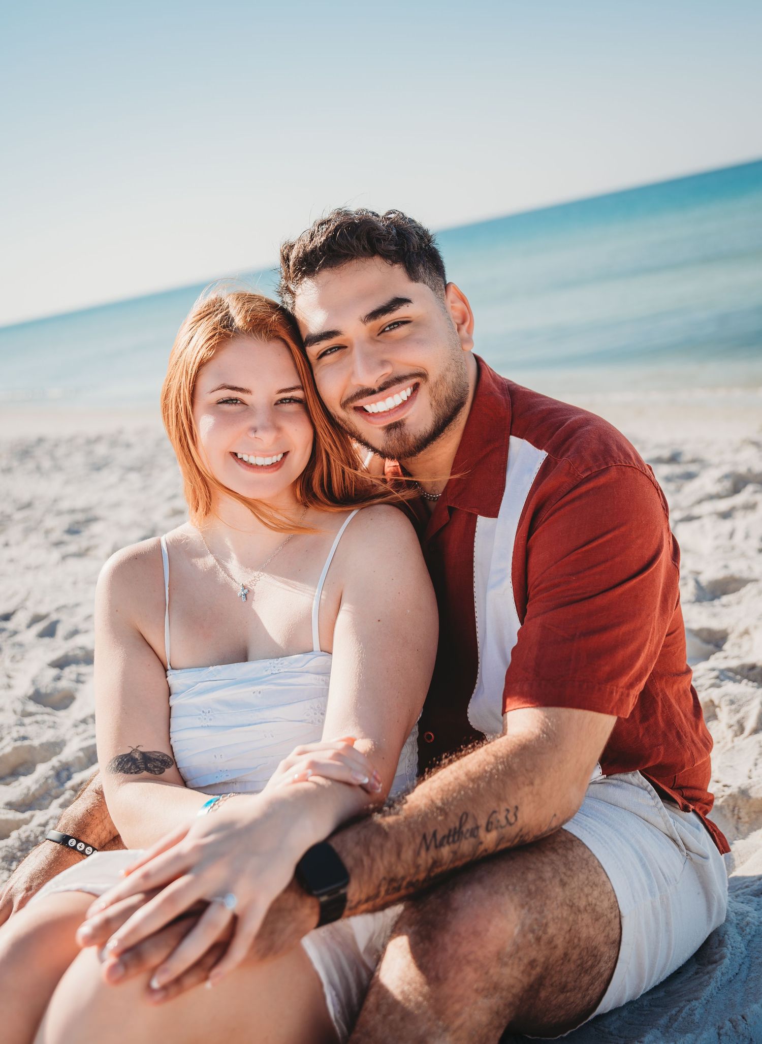Woman in white summer dress shows off her new engagement ring after a surprise proposal in Panama City Beach.