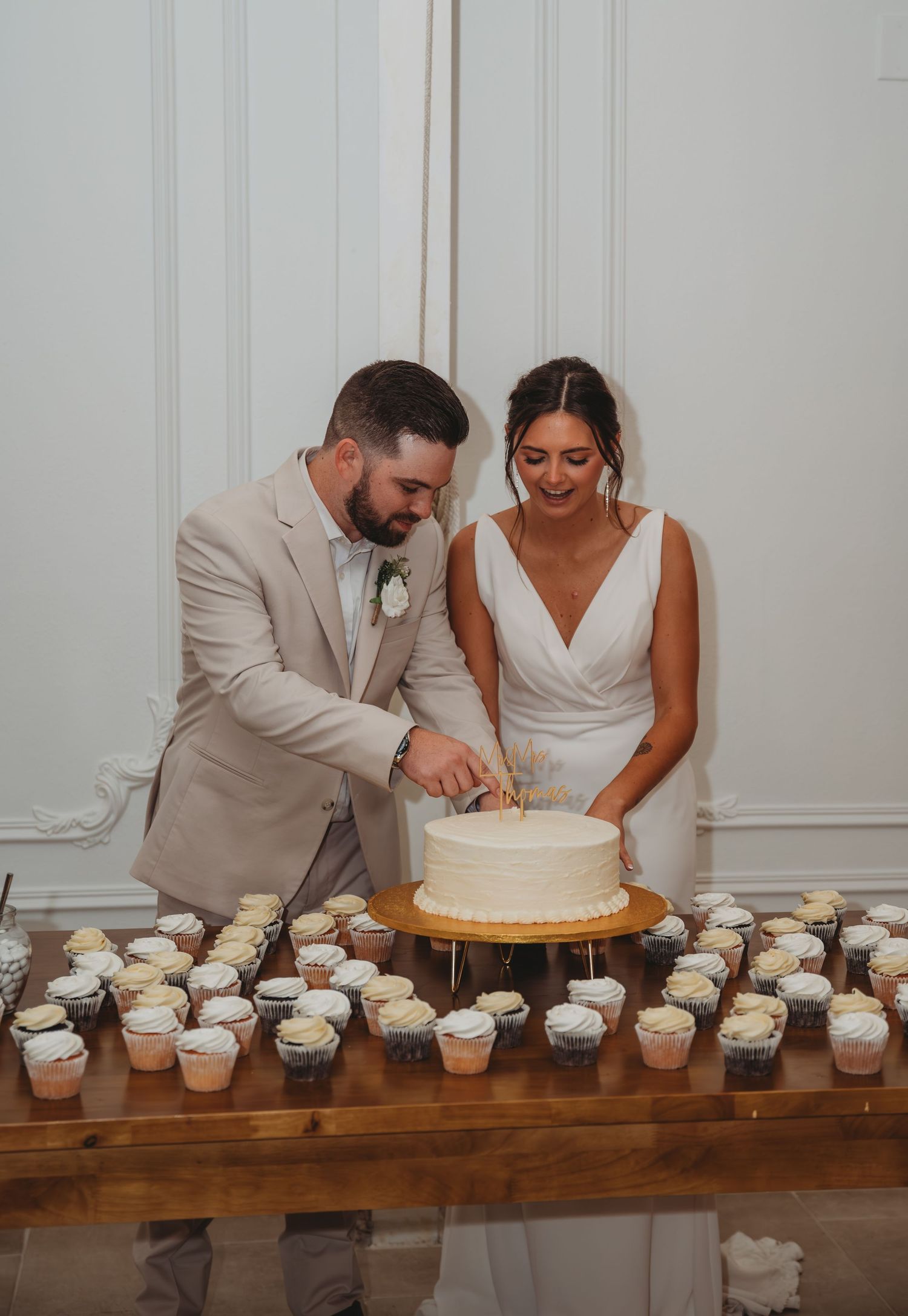 A couple in wedding attire cuts their white wedding cake together during a Panama City Beach wedding.