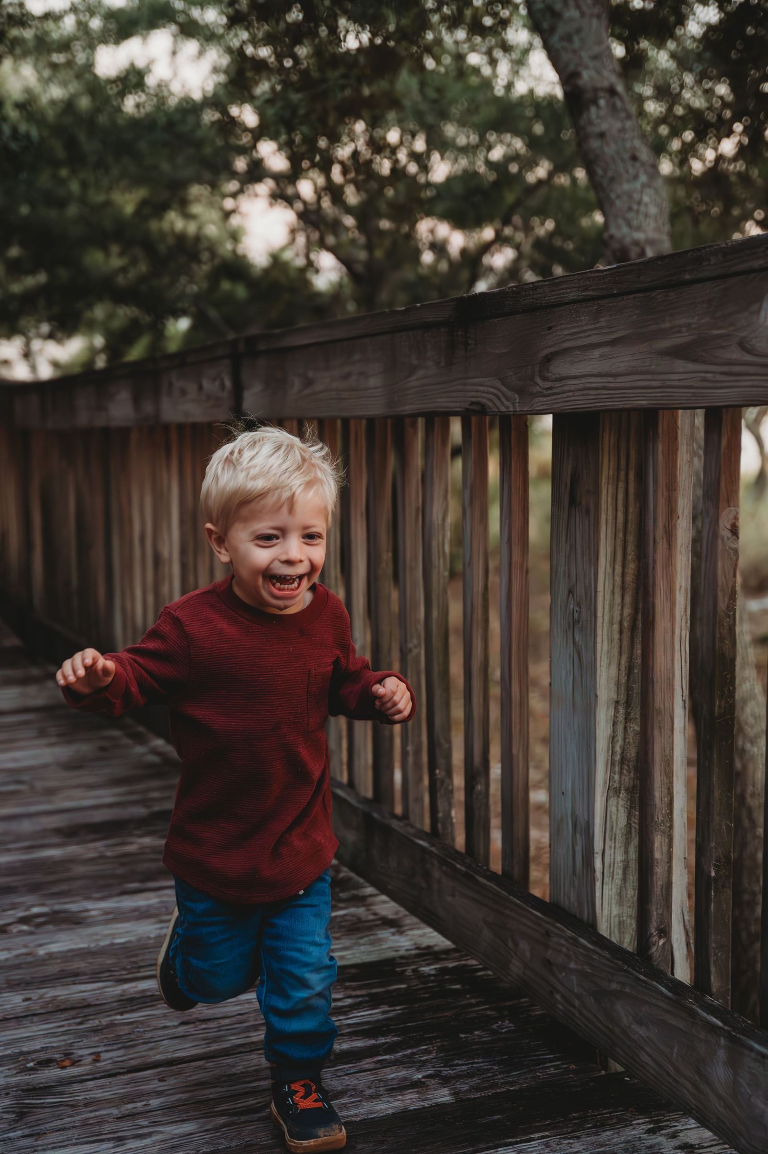 A sequence of photos showing a small child in a red sweater playing and running along a wooden deck at sunset in 30A.