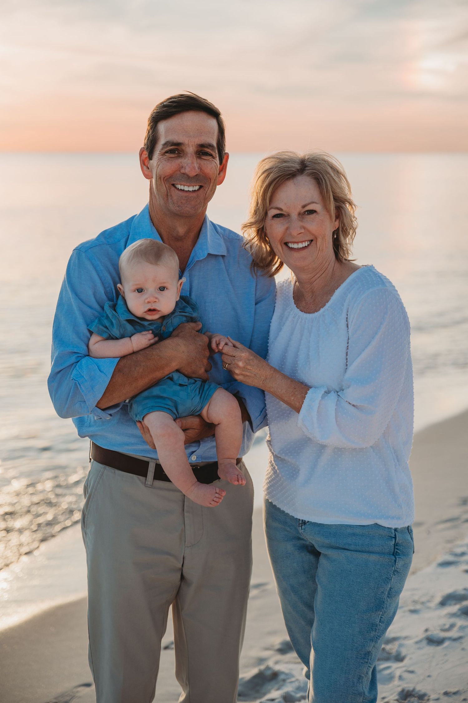 A family in blue and white outfits shares joyful moments together during a sunset photoshoot in 30A.