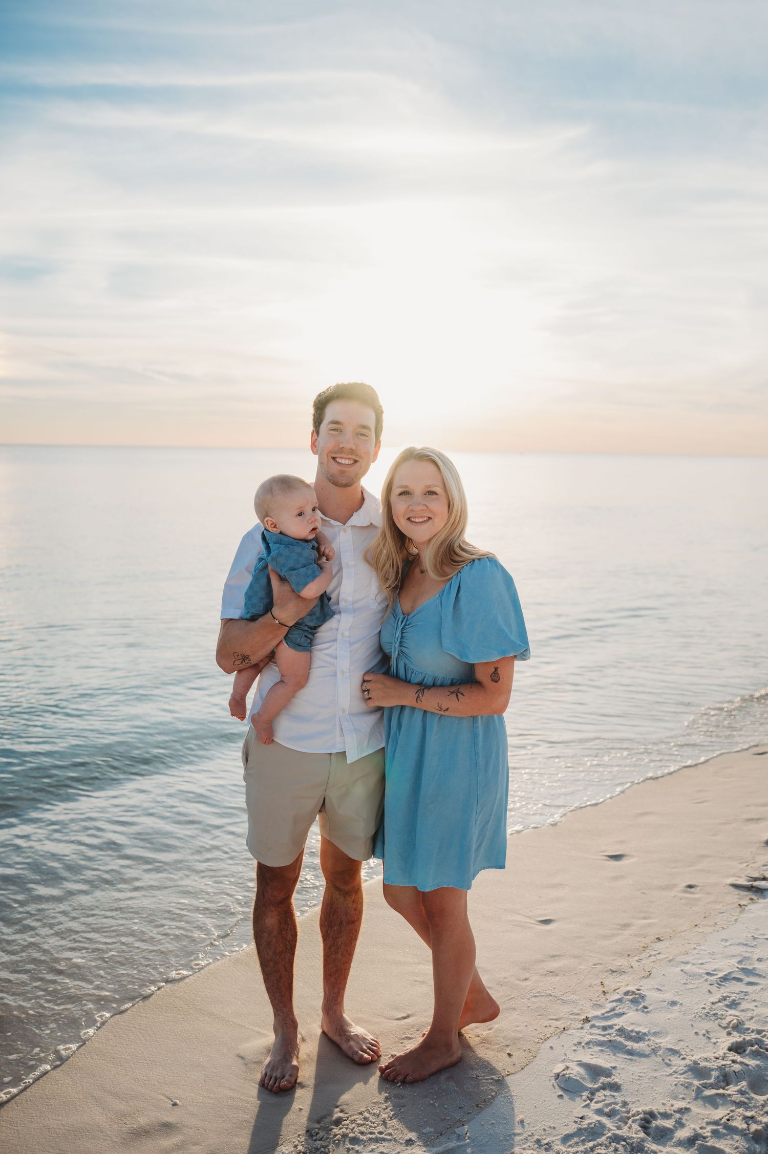 A family enjoys a peaceful sunset moment together in Panama City Beach with calm ocean waters and soft lighting in the background.