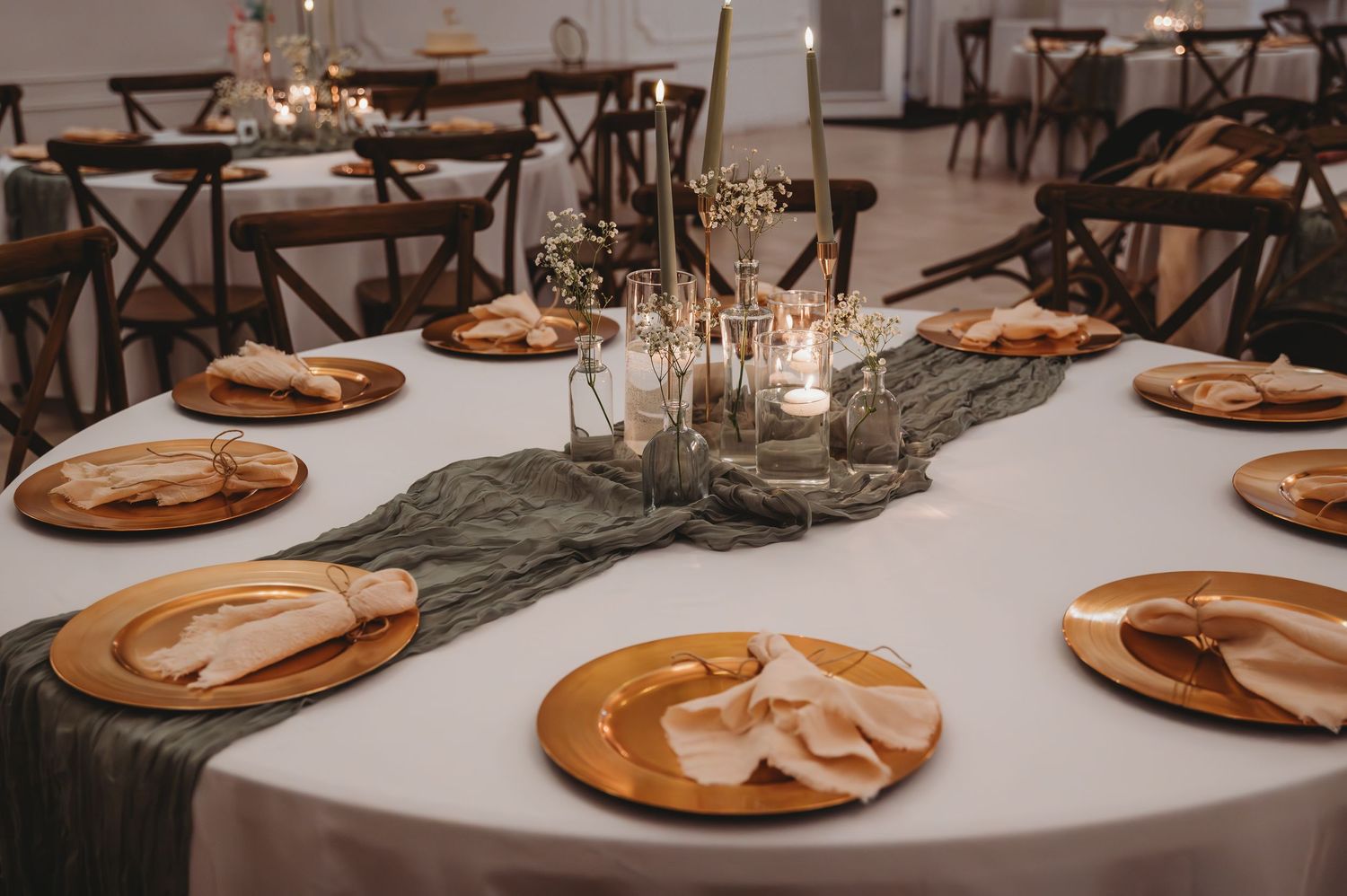 Elegant wedding reception table settings with terracotta charger plates and white linens during a Panama City Beach wedding.
