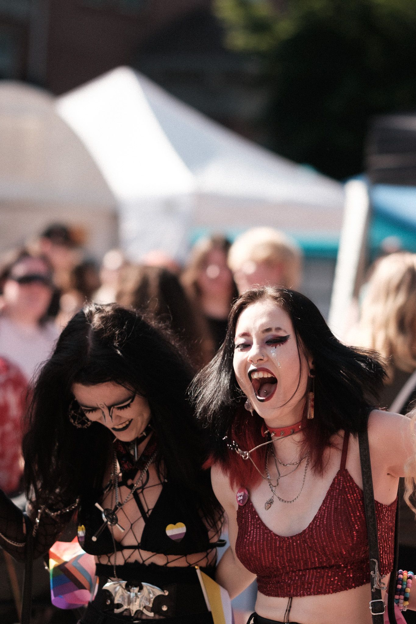 Two festival goers in gothic-inspired outfits enjoying an outdoor music event.