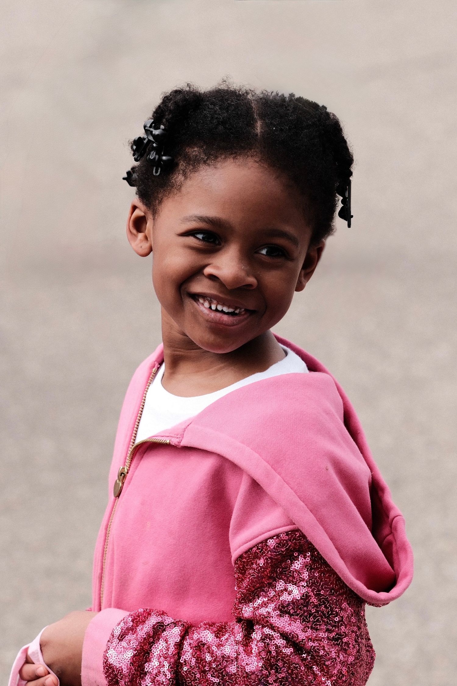 Young child wearing a pink sparkly outfit showing progressive expressions of joy.