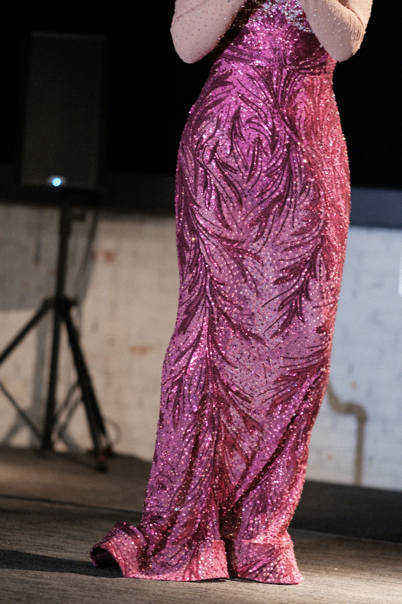 Pink sequined gown with intricate patterns shimmering under stage lights.