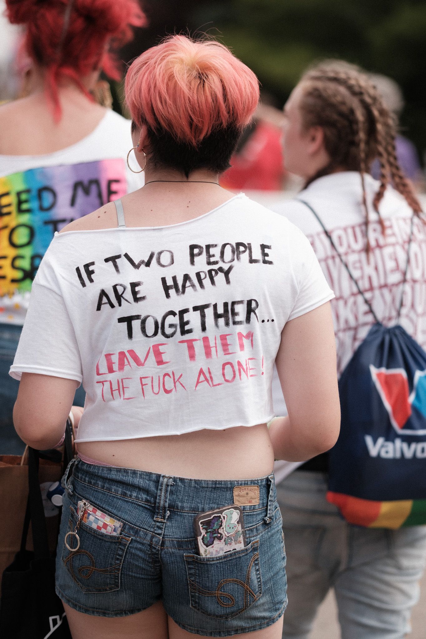 Row of people wearing t-shirts with handwritten messages about love and togetherness.