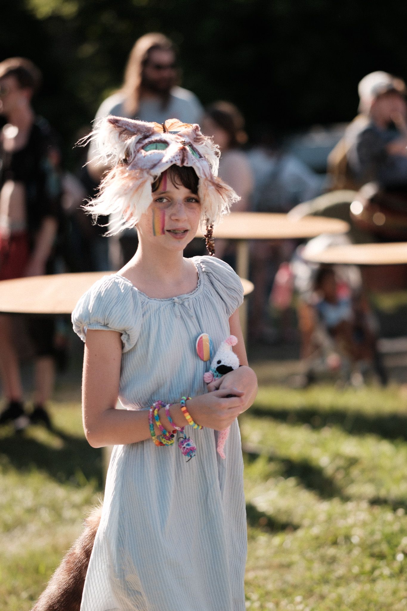 A whimsical festival attendee wearing a light blue dress and cat-ear headpiece.
