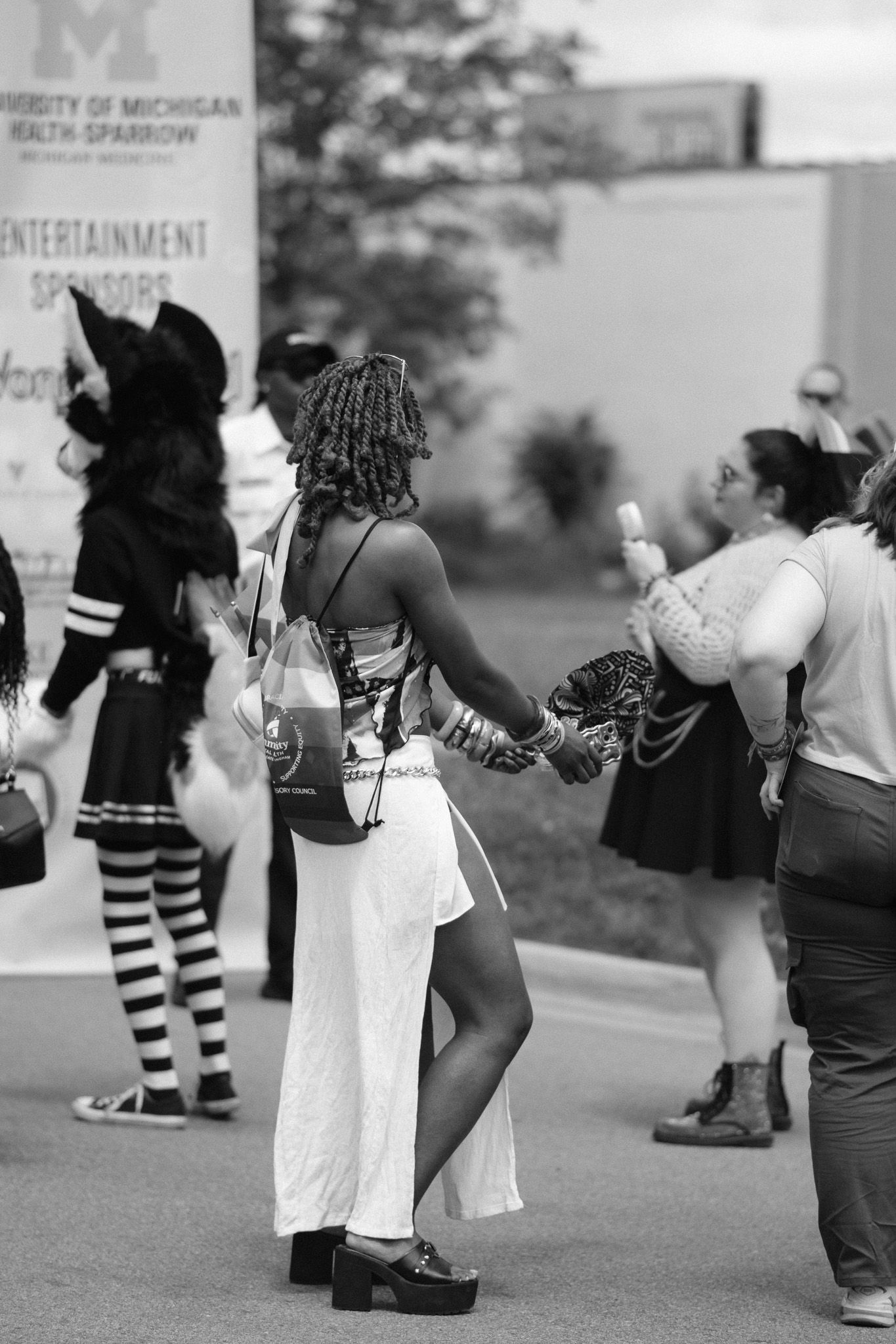 Black and white photo of festival attendees in creative outfits posing during an outdoor event.